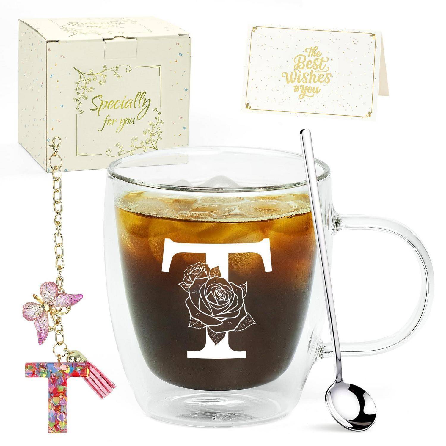 Klare Glastasse mit kaltem dunklem Getränk, Löffel und floralem „T