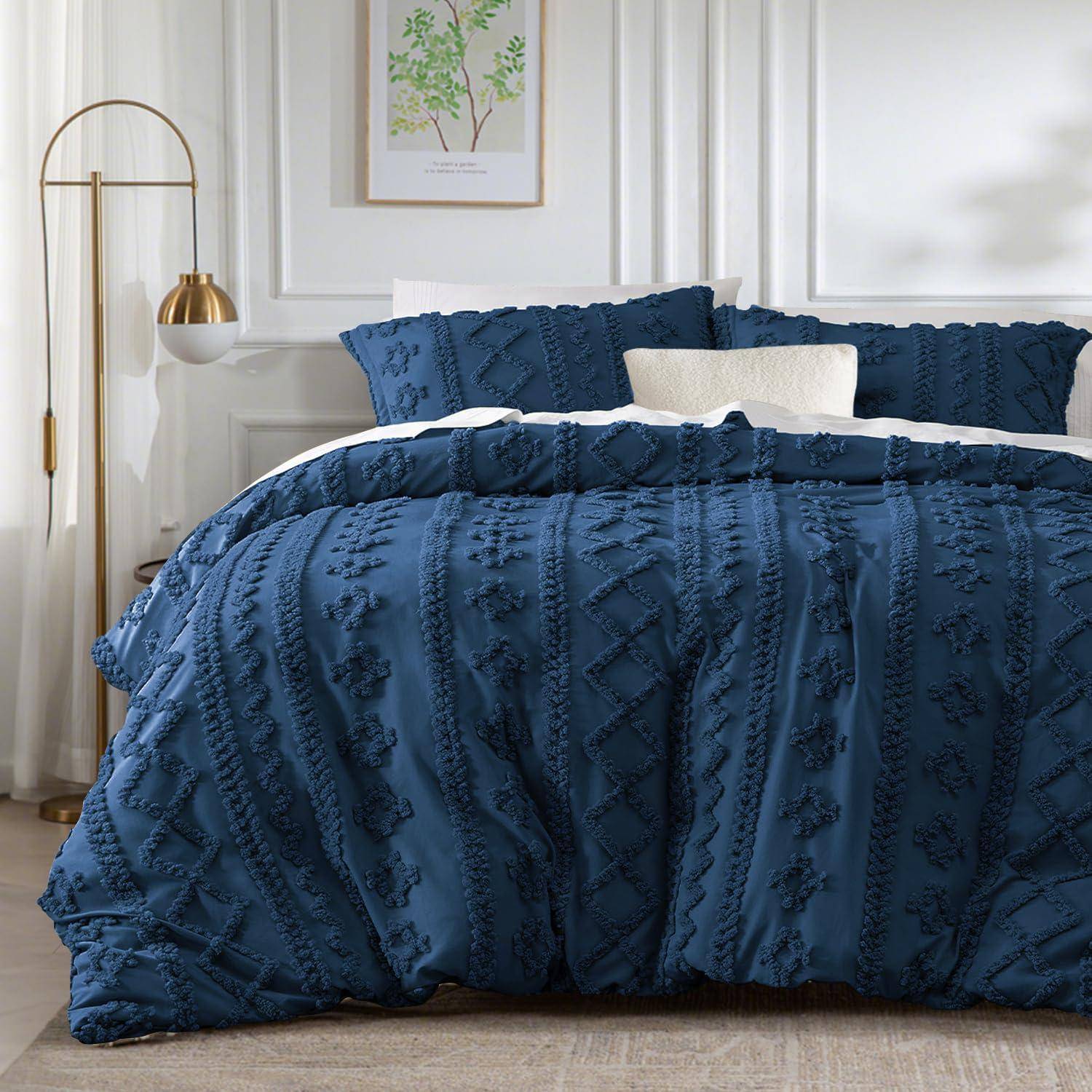 Sauber gemachtes Bett mit dunkelblauer strukturierter Bettwäsche und Kissen in einem hellen, modernen Schlafzimmer.