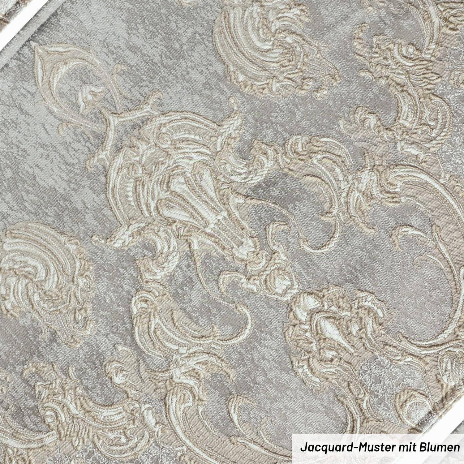 Nahaufnahme eines grauen Jacquard-Gewebes mit erhabenerem cremefarbigem Blumenmuster; kleines Etikett mit der Aufschrift „Jacquard-Muster mit Blumen".