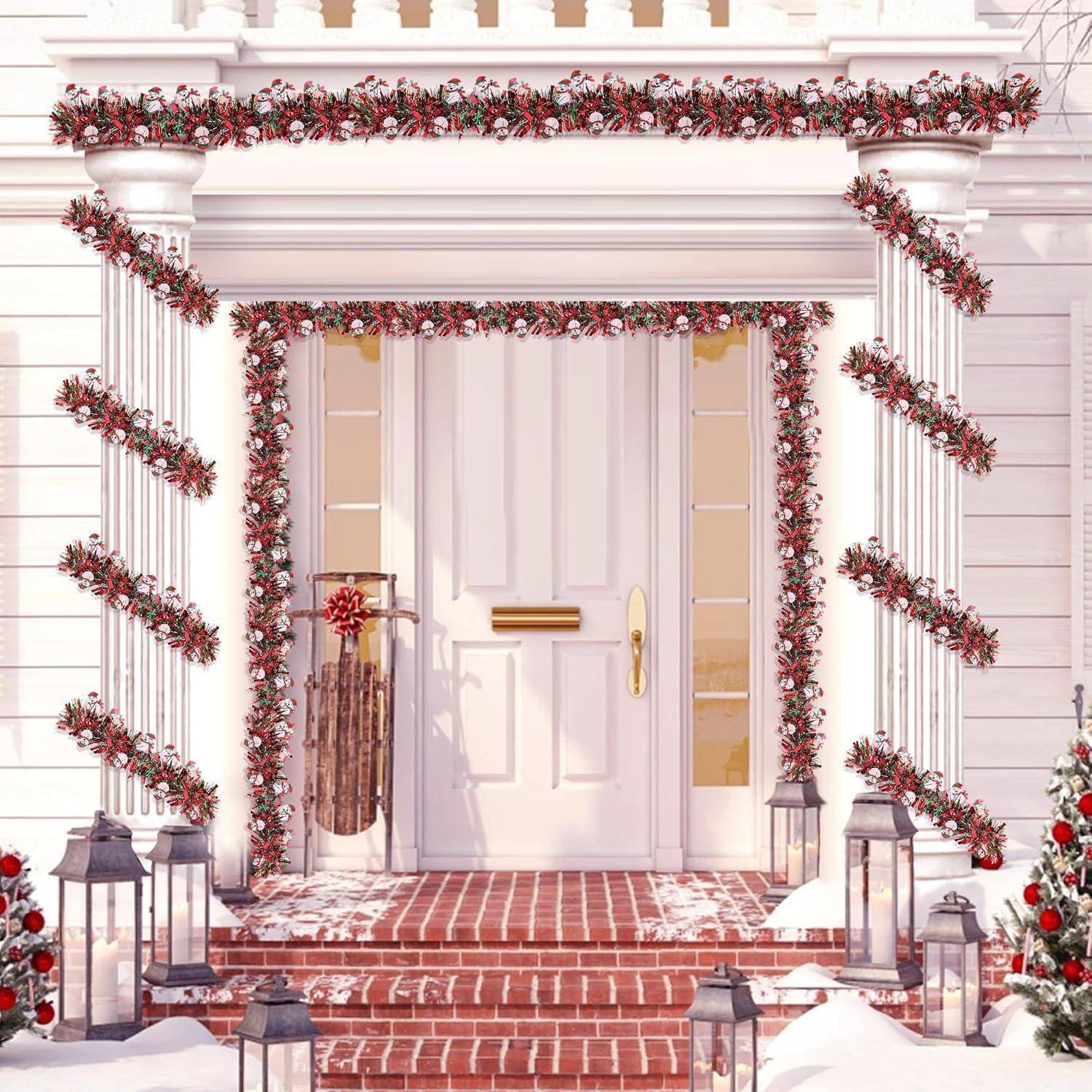 Schneebedeckte Veranda mit weißer Tür, dekoriert mit roten Girlanden, Kranz, Laternen und einem Ziegelsteineingang, was einen festlichen weihnachtlichen Hauseingang andeutet.