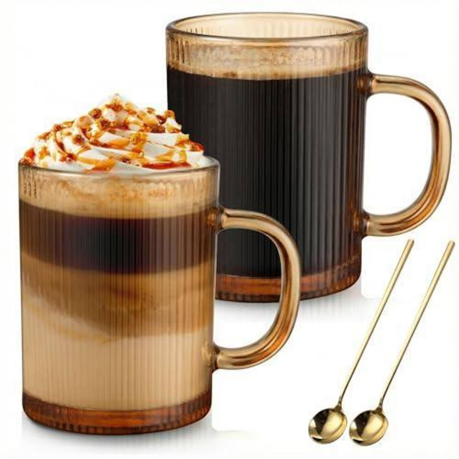Zwei Glastassen mit geschichteten Kaffeegetränken, eine mit Schlagsahne und Karamellsirup garniert, mit zwei goldenen Löffeln auf weißem Hintergrund.