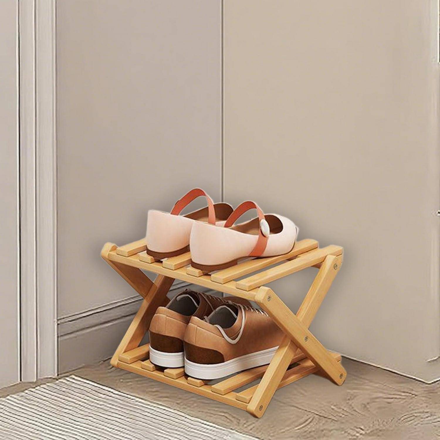 Holzschuhregal mit zwei Ebenen, das zwei Paar Schuhe hält, an einer Wand auf einem gestreiften Teppich aufgestellt.