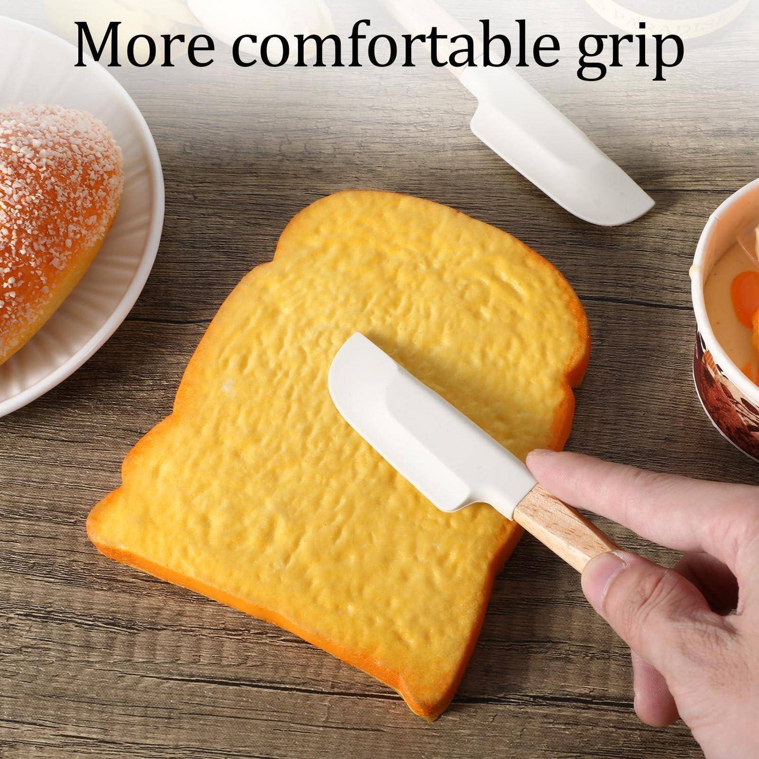 Hand, die einen weißen Belag mit einem kleinen Spachtel auf Toast verteilt; Text sagt „Bequemerer Griff