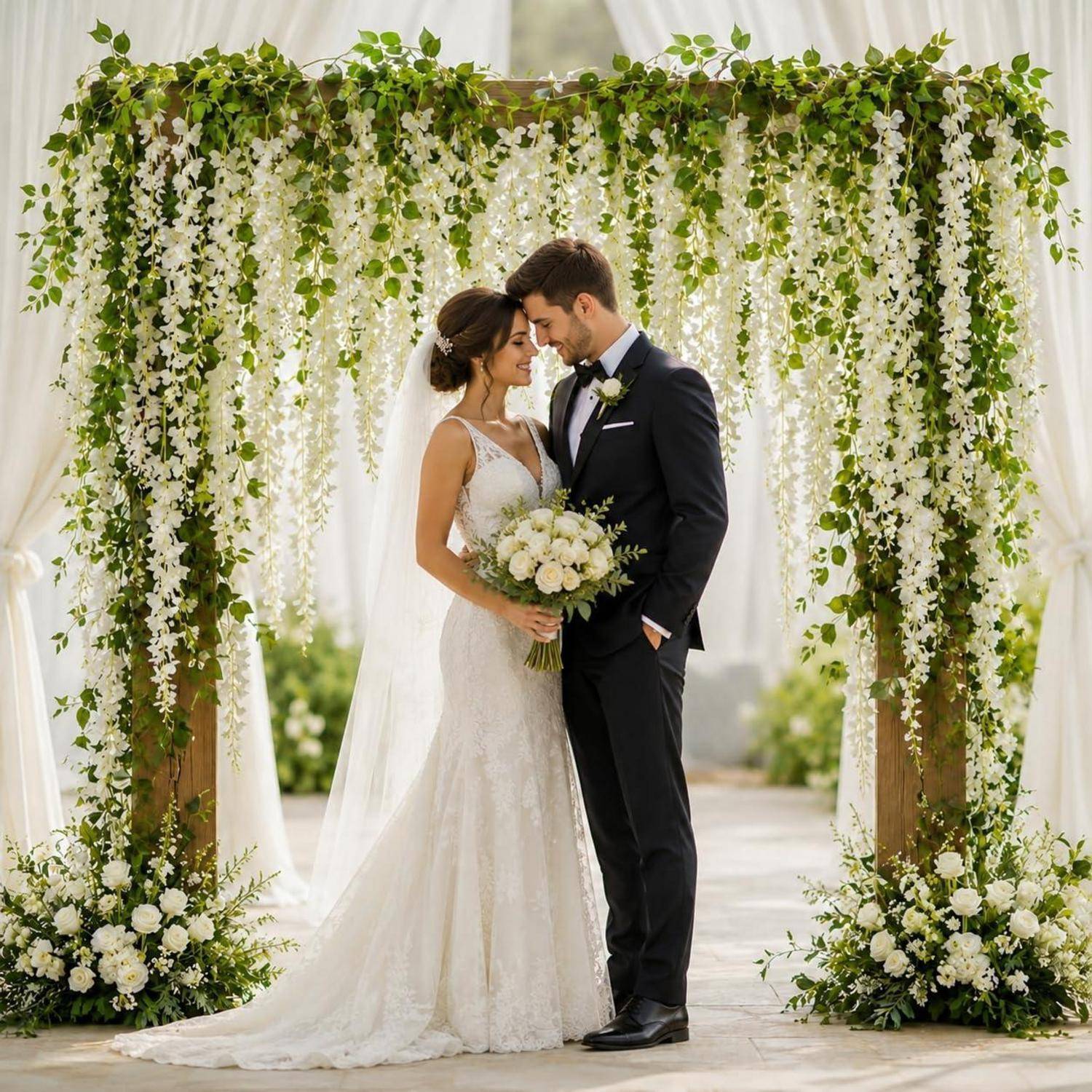 Braut und Bräutigam stehen eng beieinander unter einem Blumenbogen bei ihrer Hochzeit, halten einen Blumenstrauß und blicken sich gegenseitig an.