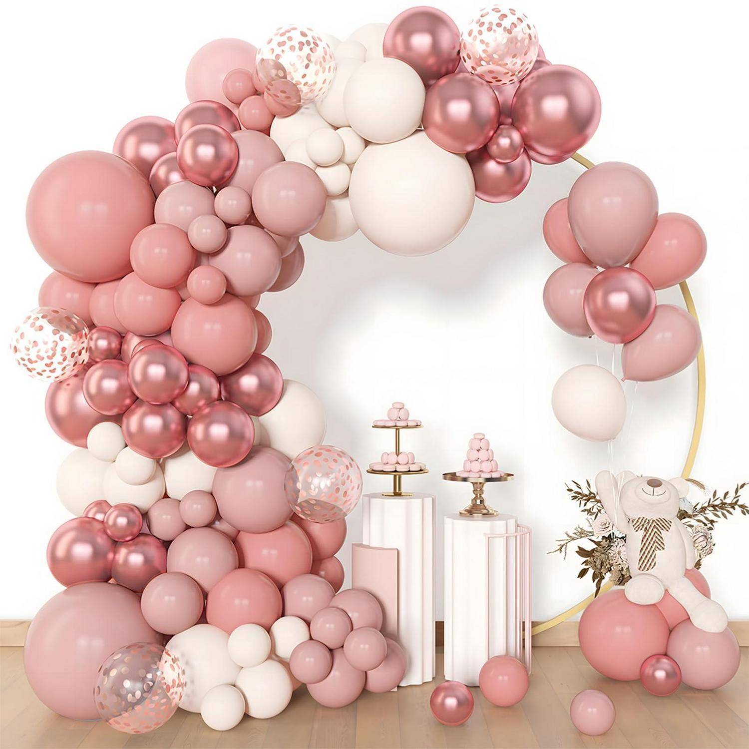 Rosa- und weißer Ballonbogen um eine Partydisplay mit Sockeln und einer Teddybär-Mittelstückanordnung, die einen Hintergrund für eine Babyparty oder Feier schafft.