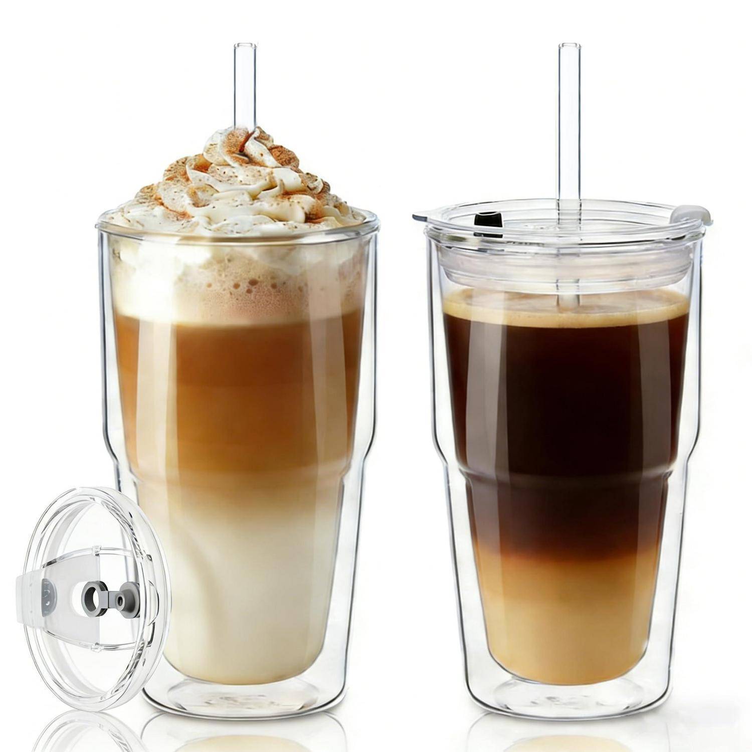 Zwei transparente doppelwandige Tumbler mit wiederverwendbaren Strohhalmen, einer mit Eiskaffee mit Schlagsahne und Zimt, der andere mit geschichtetem schwarzem Kaffee.