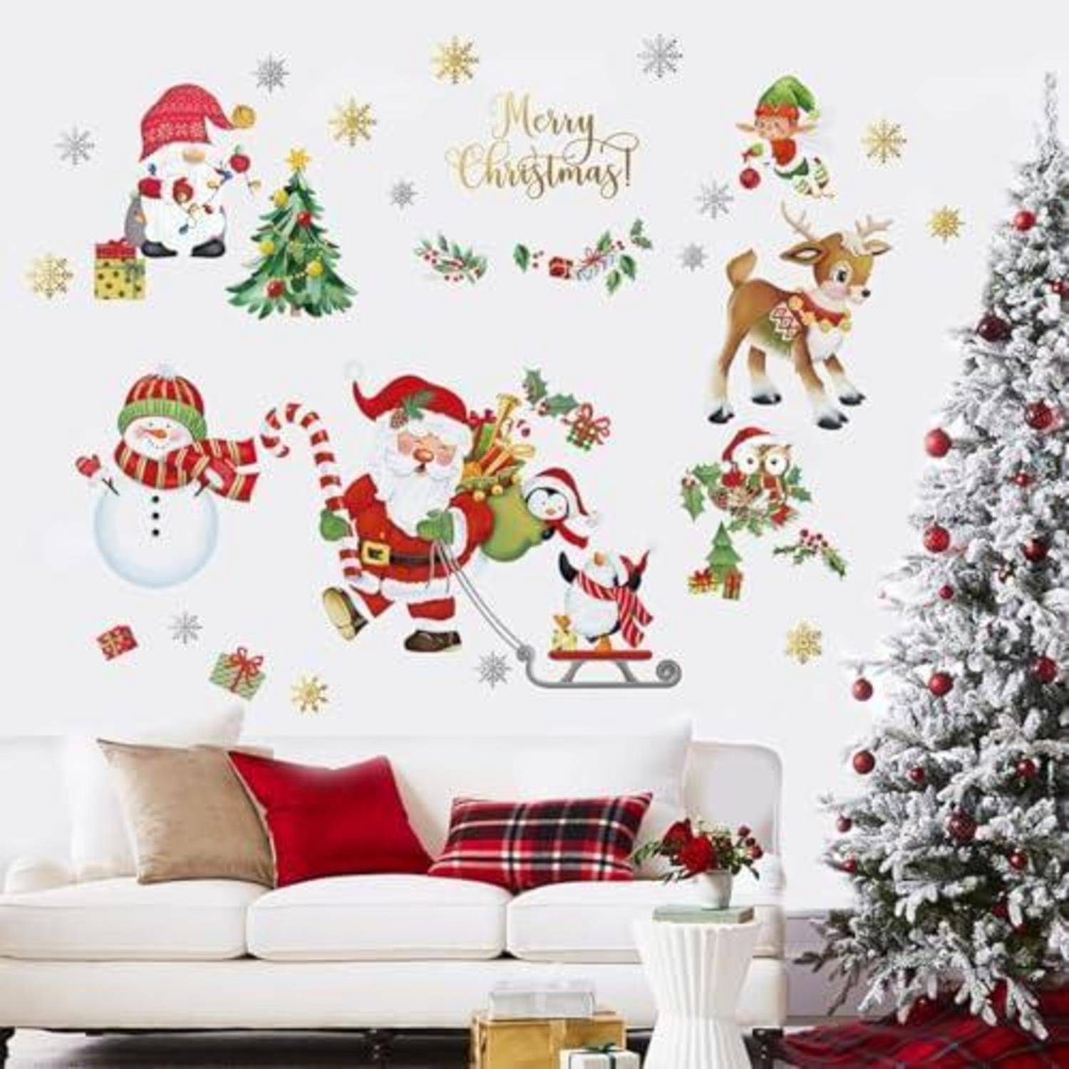 Wohnzimmer zu Weihnachten mit dekoriertem Baum, weißem Sofa und Wandaufklebern mit Weihnachtsmann, Schneemann, Rentier, Schneeflocken und dem Text „Frohe Weihnachten".