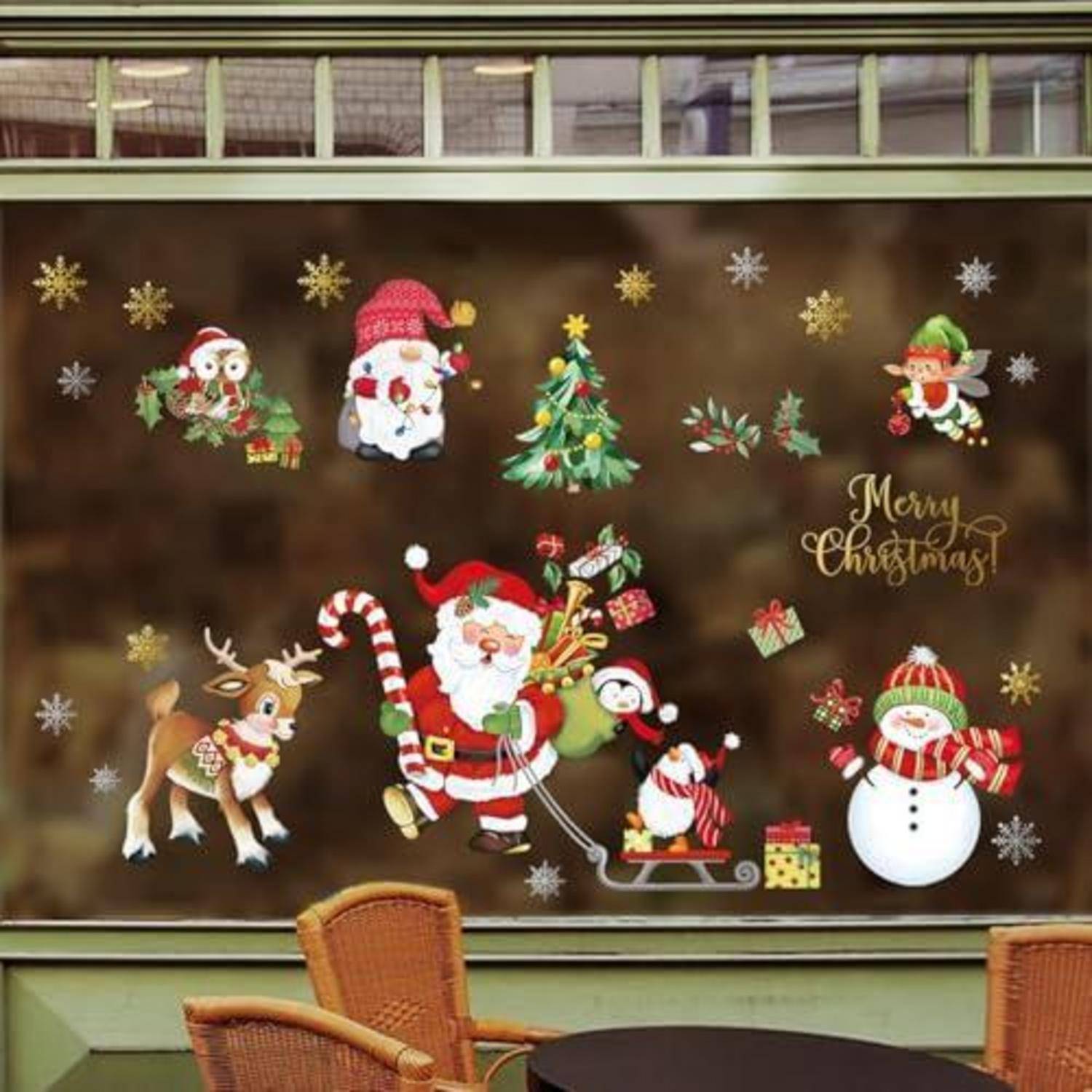 Weihnachtsschaufenster mit dem Weihnachtsmann, Rentieren, Schneemann, Pinguin, Elfen, Baum, Geschenken und dem Text „Frohe Weihnachten" auf braunem Hintergrund.