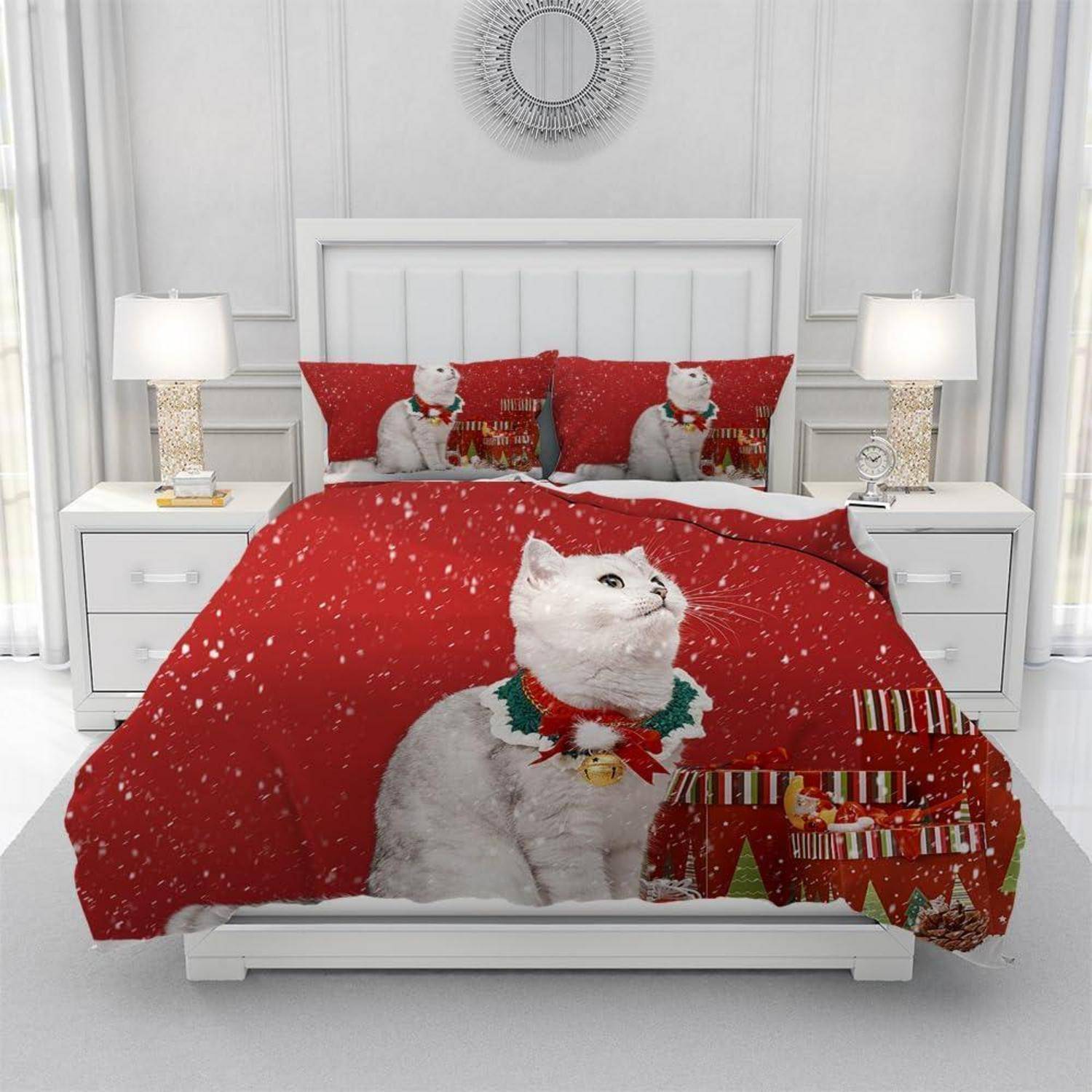 Weißes Schlafzimmer mit einem Bett, das in roter Weihnachts-Katzendruck-Bettwäsche eingedeckt ist, flankiert von passenden Nachttischen und Lampen.