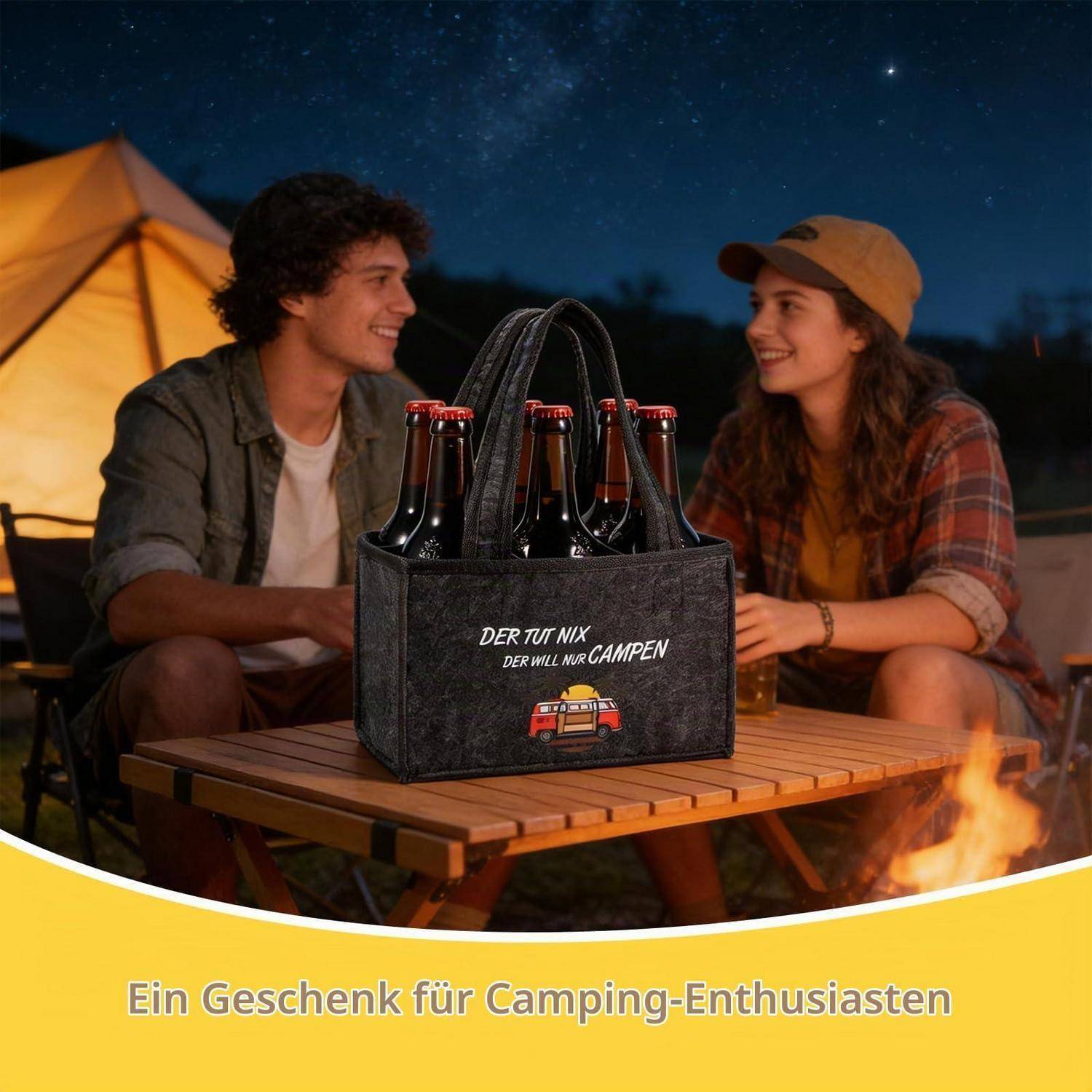 Lachendes Paar auf einem Campingplatz sitzt an einem Tisch mit einem Sechserpack-Träger mit der Aufschrift „DER TUT NIX DER WILL NUR CAMPEN