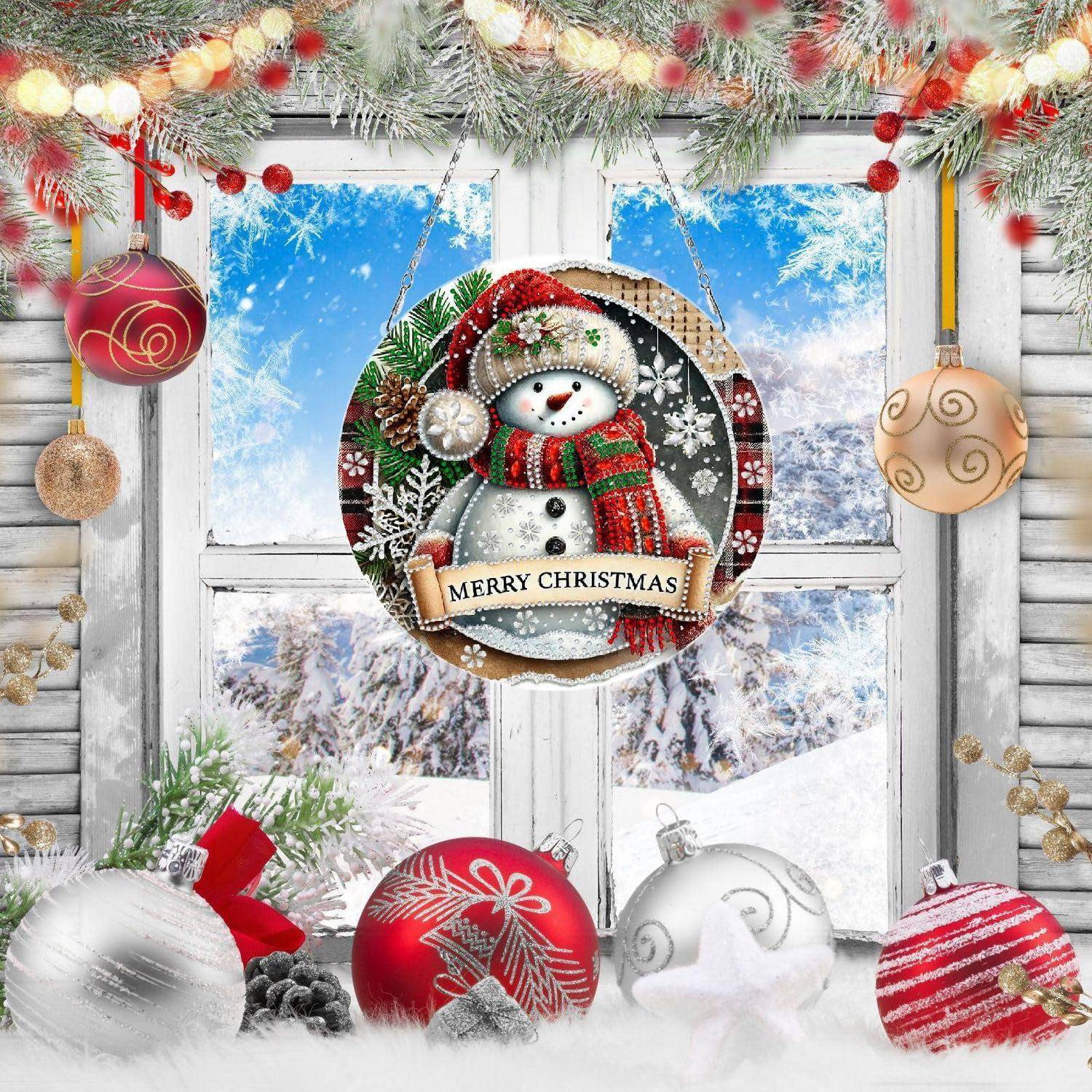 Schneemann-Weihnachtsschmuck mit Banner „FROHE WEIHNACHTEN", der in einer verschneiten Fensterszene hängt, umgeben von festlichen Kugeln und Girlanden.
