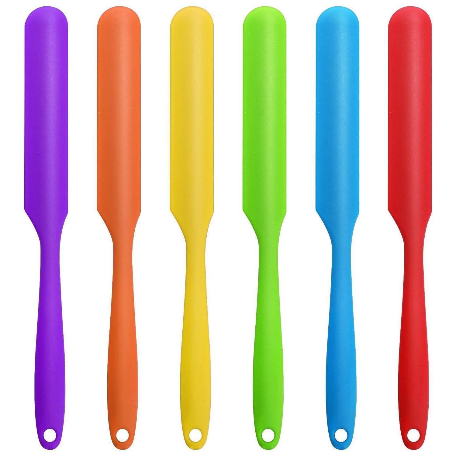 Sechs bunte Küchenschaber oder Küchenutenisilien stehen aufrecht in Lila, Orange, Gelb, Grün, Blau und Rot auf weißem Hintergrund.