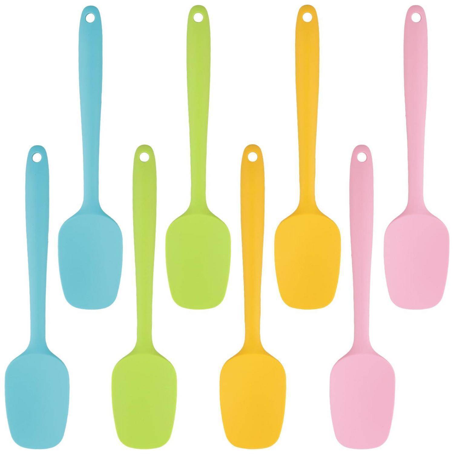 Satz farbenfroher Silikon-Spatel oder Spoonula-Werkzeuge in Blau, Grün, Gelb und Rosa auf weißem Hintergrund.