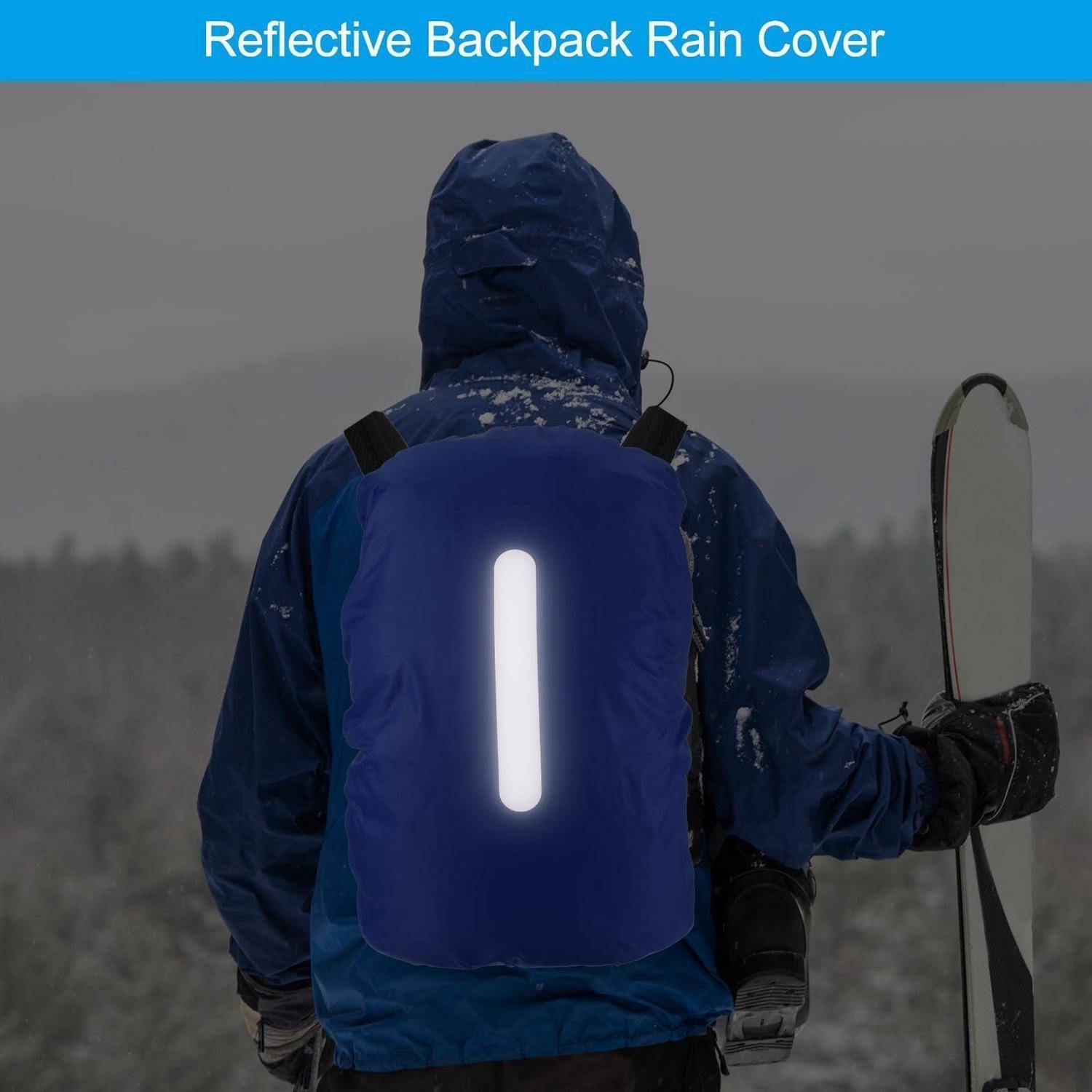 Person in blauem Winterkleidung, die eine reflektierende Regenschutzhülle für den Rucksack mit hellen vertikalen Leuchtstreifen trägt, steht im Freien unter Schneebedingungen und hält einen Ski.