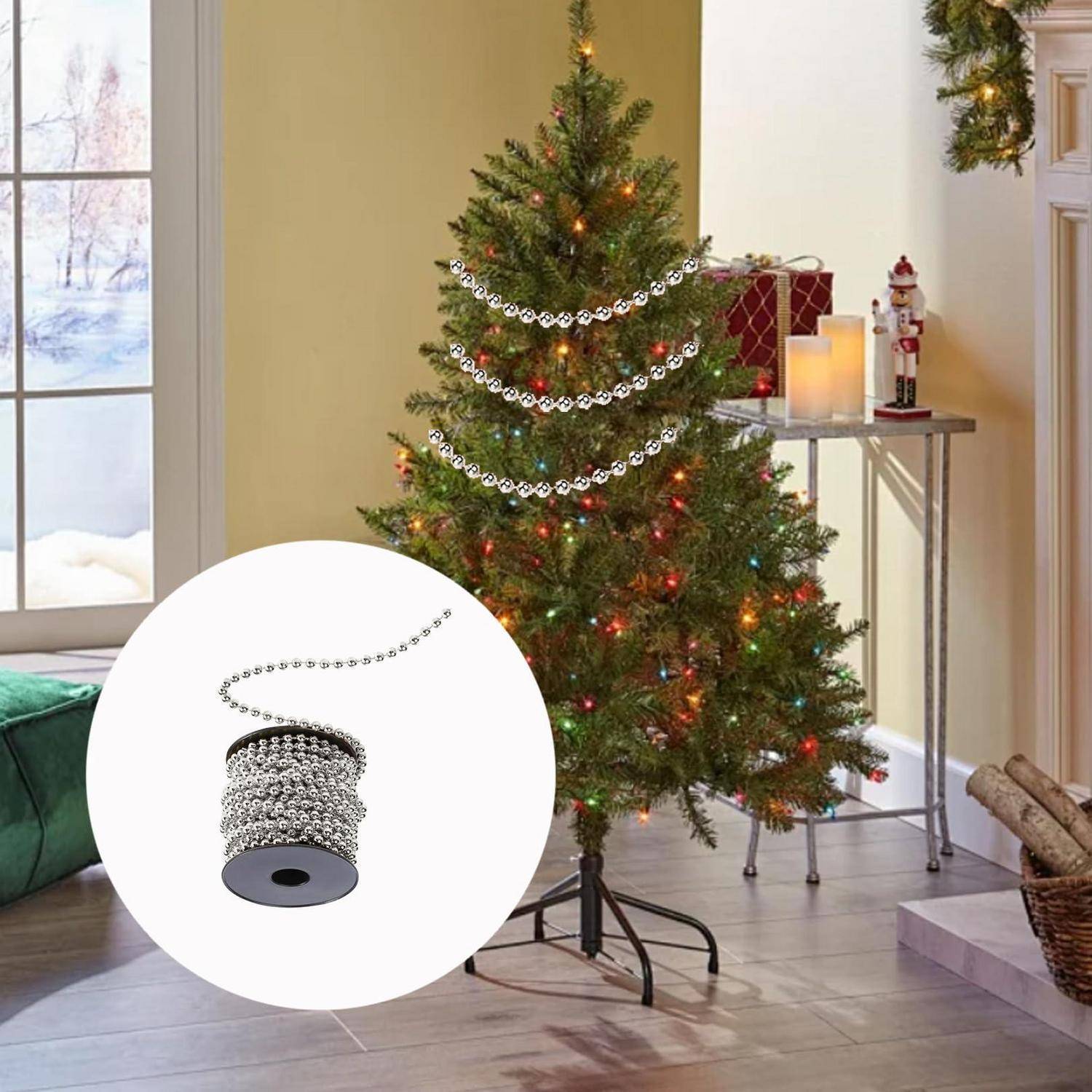 Geschmückter Weihnachtsbaum mit mehrfarbigen Lichtern und silbernen Girlanden in einem Wohnzimmer; die Einführung zeigt eine Spule mit silberner Perlgirlande.