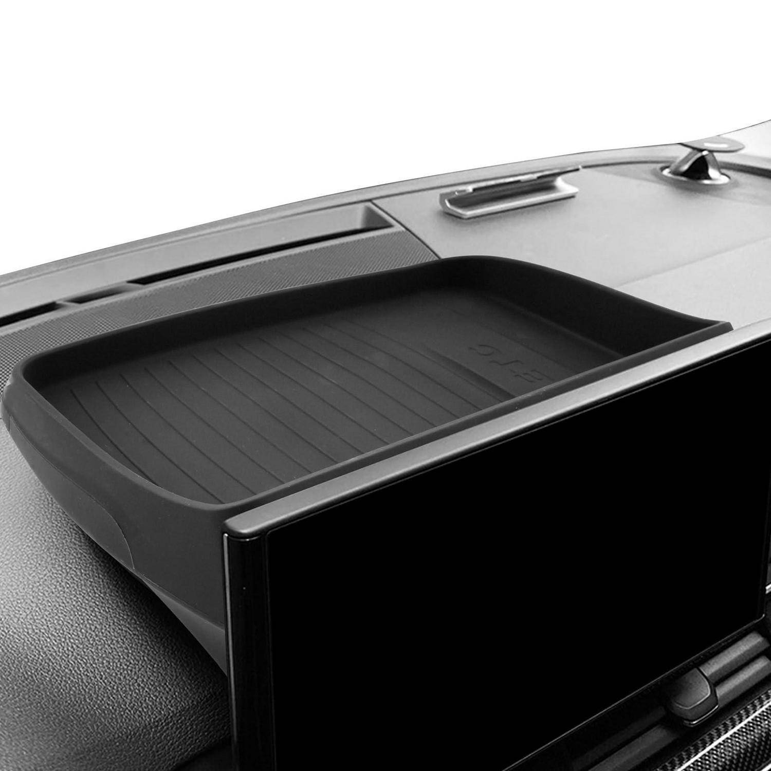 Nahaufnahme einer Mittelkonsole im Autoinnenraum mit einem offenen Ablagefach und einem leeren Touchscreen-Display