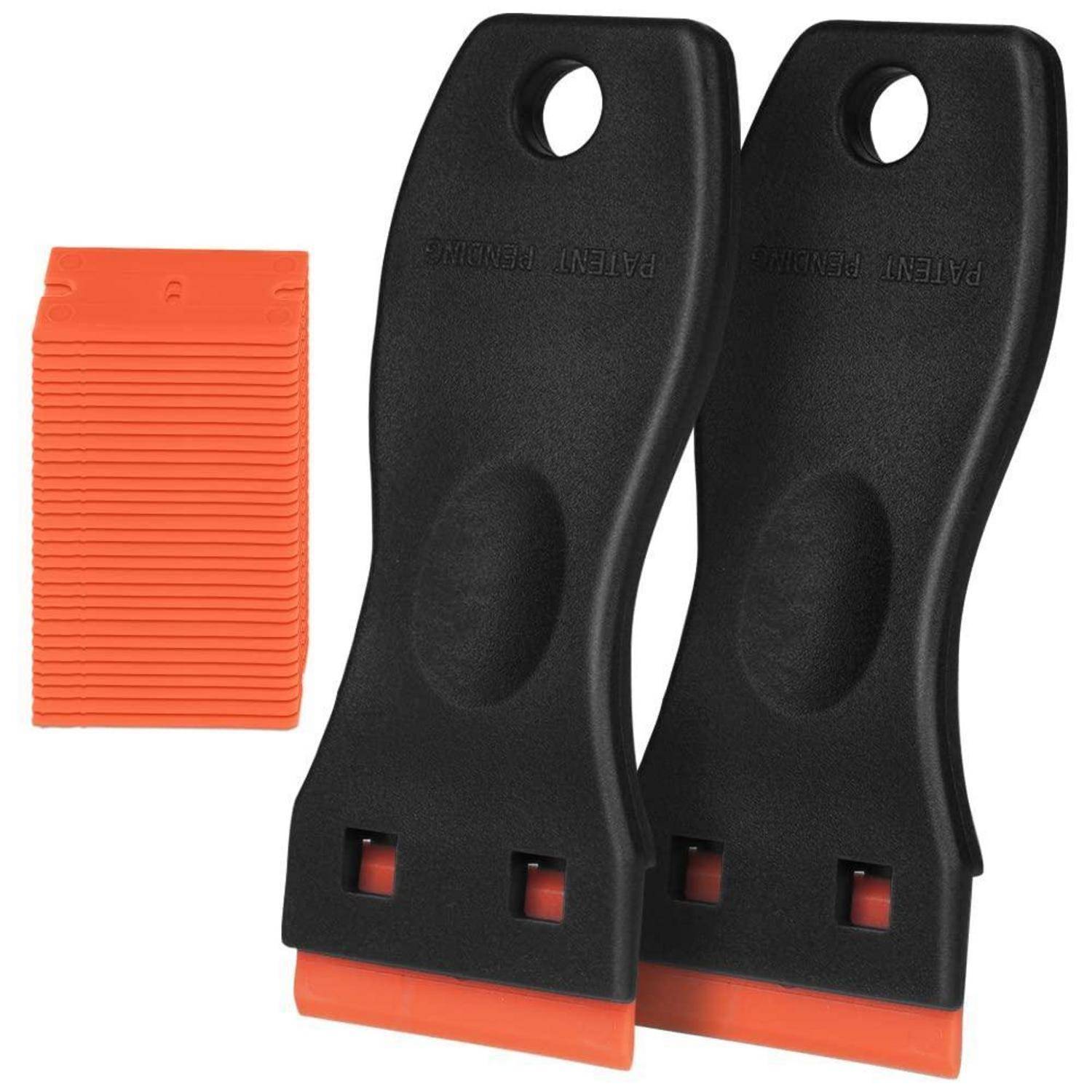 Zwei schwarze Kunststoff-Handschaber mit orangefarbenen Klingen neben einer orangefarbenen gerippten Ersatzklingenpackung auf weißem Hintergrund.