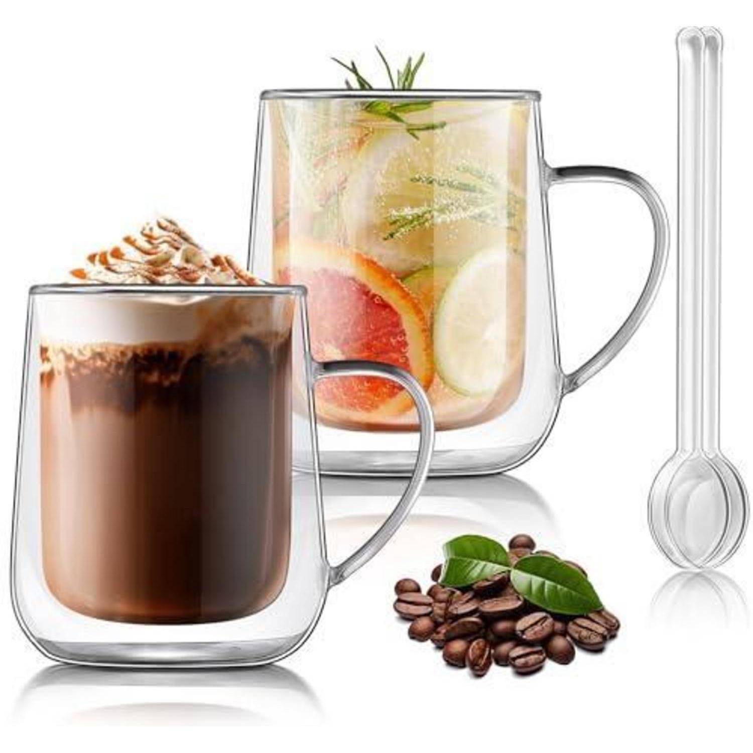 Zwei doppelwandige Glastassen: eine mit Eiskaffee, verziert mit Schlagsahne, eine mit Zitrus-Kräutertee; Kaffeebohnen und ein Glassrührlöffel in der Nähe.