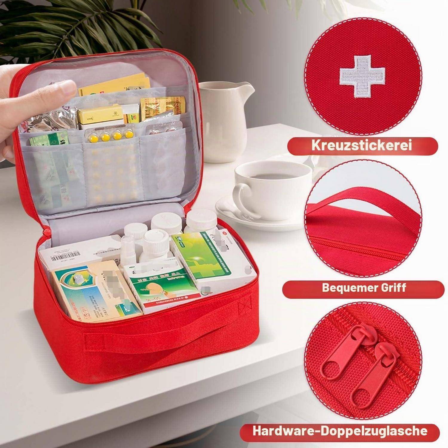 Rote Erste-Hilfe-Organizer-Tasche mit Reißverschluss, offen auf einem Tisch, mit Medikamenten und Utensilien; Beschriftungen zeigen gesticktes Kreuz, komfortabler Griff und doppelte Reißverschlüsse.