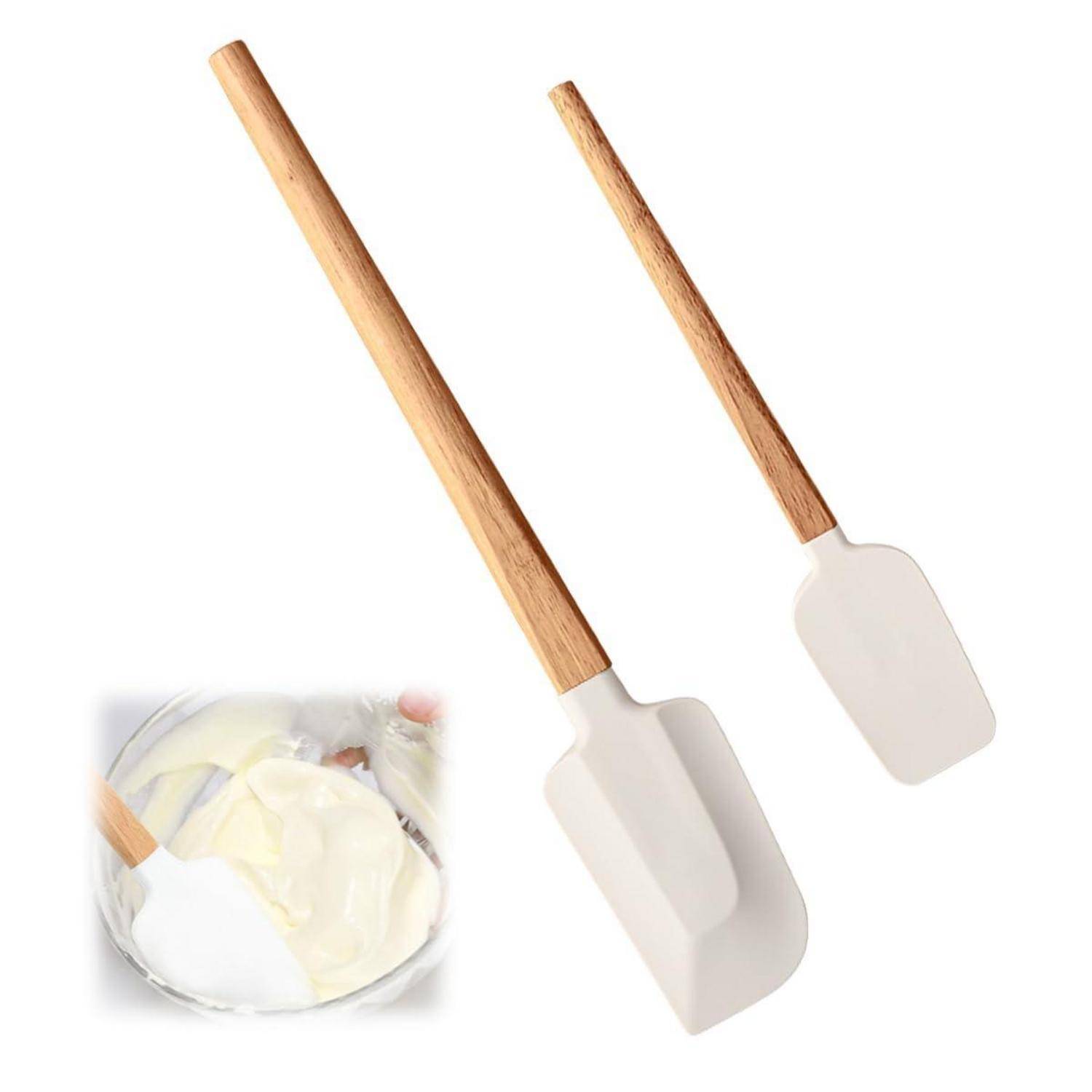 Zwei Silikon-Spatel mit Holzgriffen, plus eine kleine Einfügung, die zeigt, wie eine Schüssel mit Teig gemischt wird.