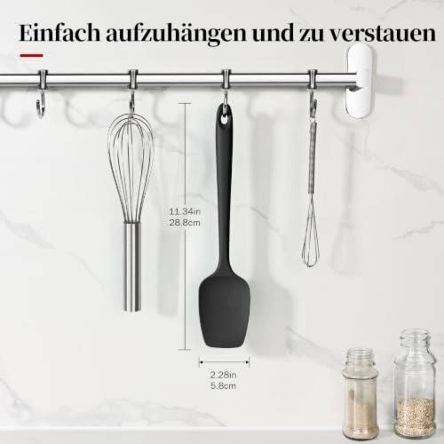 Küchenutensilien-Ständer mit hängendem Schneebesen, Spatel und Küchenzange; deutscher Text sagt „Leicht aufzuhängen und zu lagern