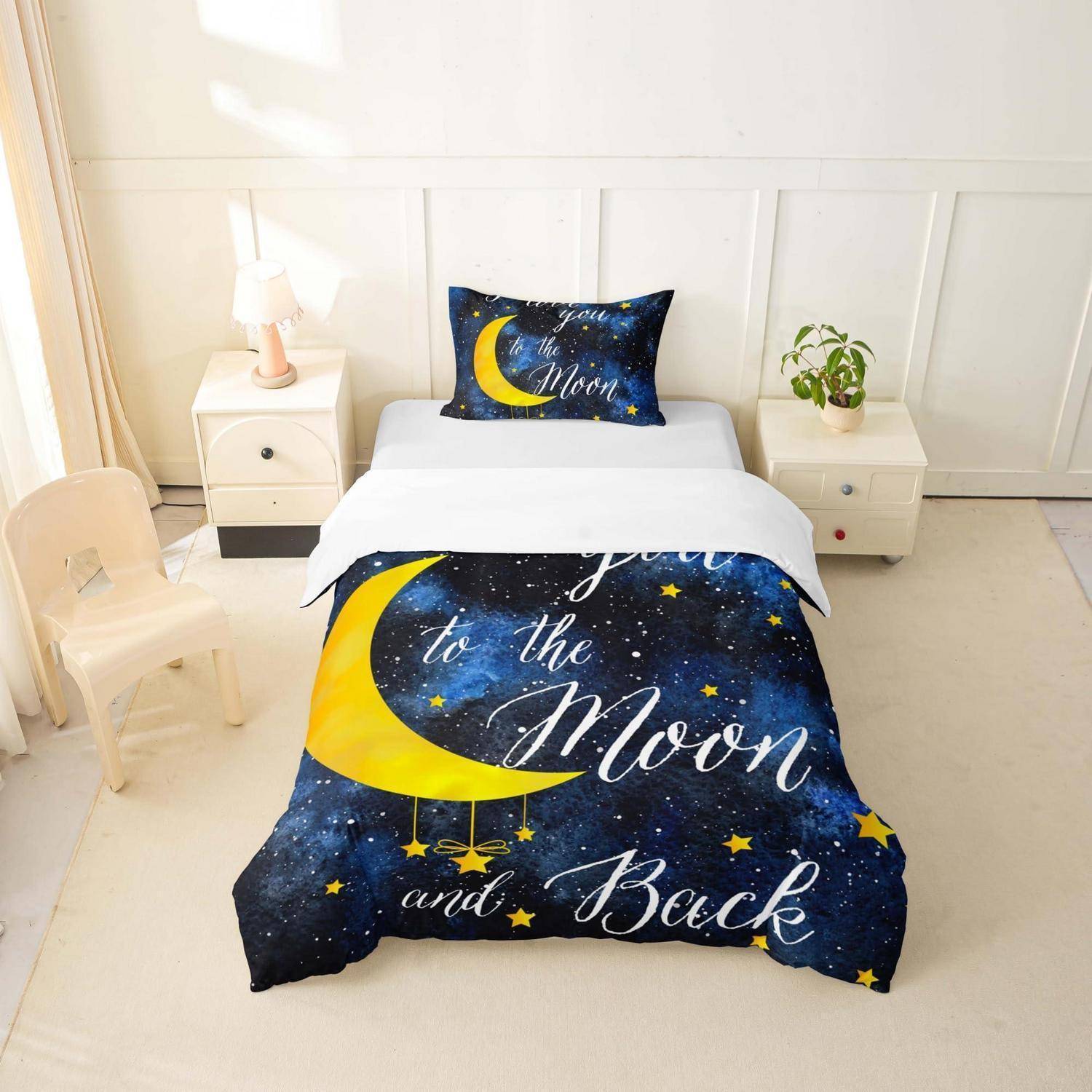 Ein Kinderbett mit einer Mond-und-Sterne-Bettdecke und Kissen mit der Aufschrift „Dich zum Mond und zurück", in einem hellen weißen Schlafzimmer mit Nachttischen, Lampe und Pflanze.