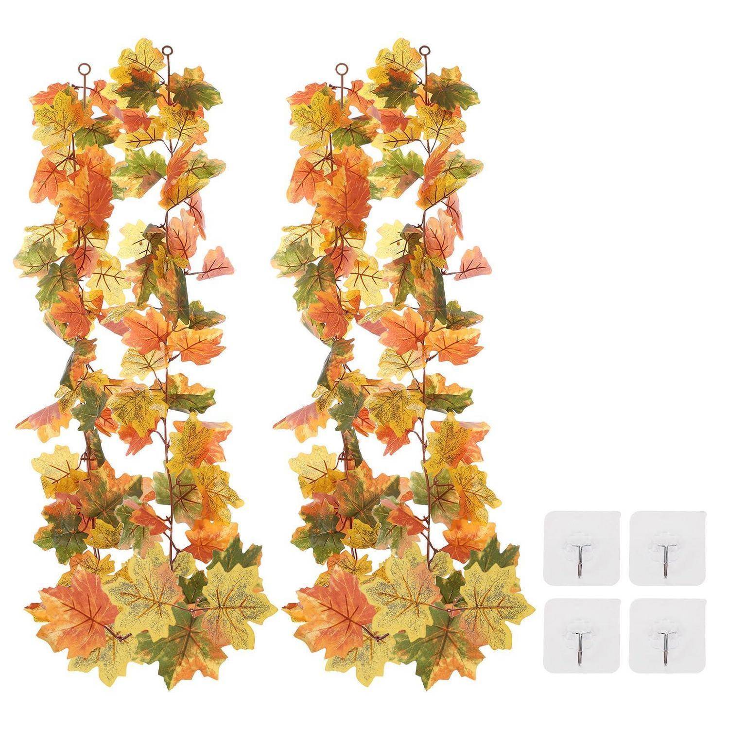 Zwei hängende künstliche Herbstblatt-Girlanden mit orangefarbenen, gelben und grünen Blättern, plus vier Klebewandhaken zum Befestigen.