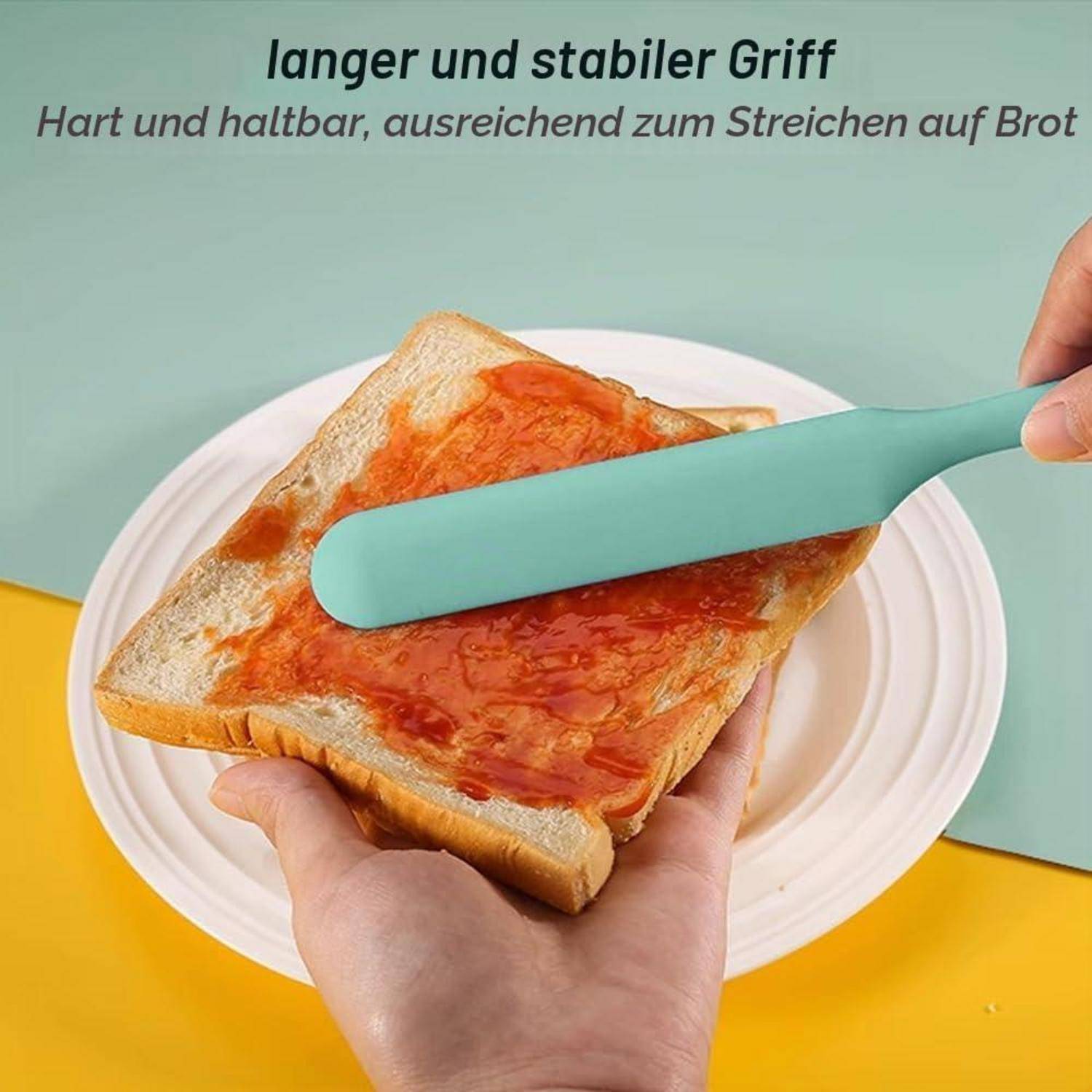 Hände verteilen rote Marmelade auf einer Brotscheibe mit einem langen mintgrünen Spachtel über einem weißen Teller; deutscher Text besagt „langer und stabiler Griff
