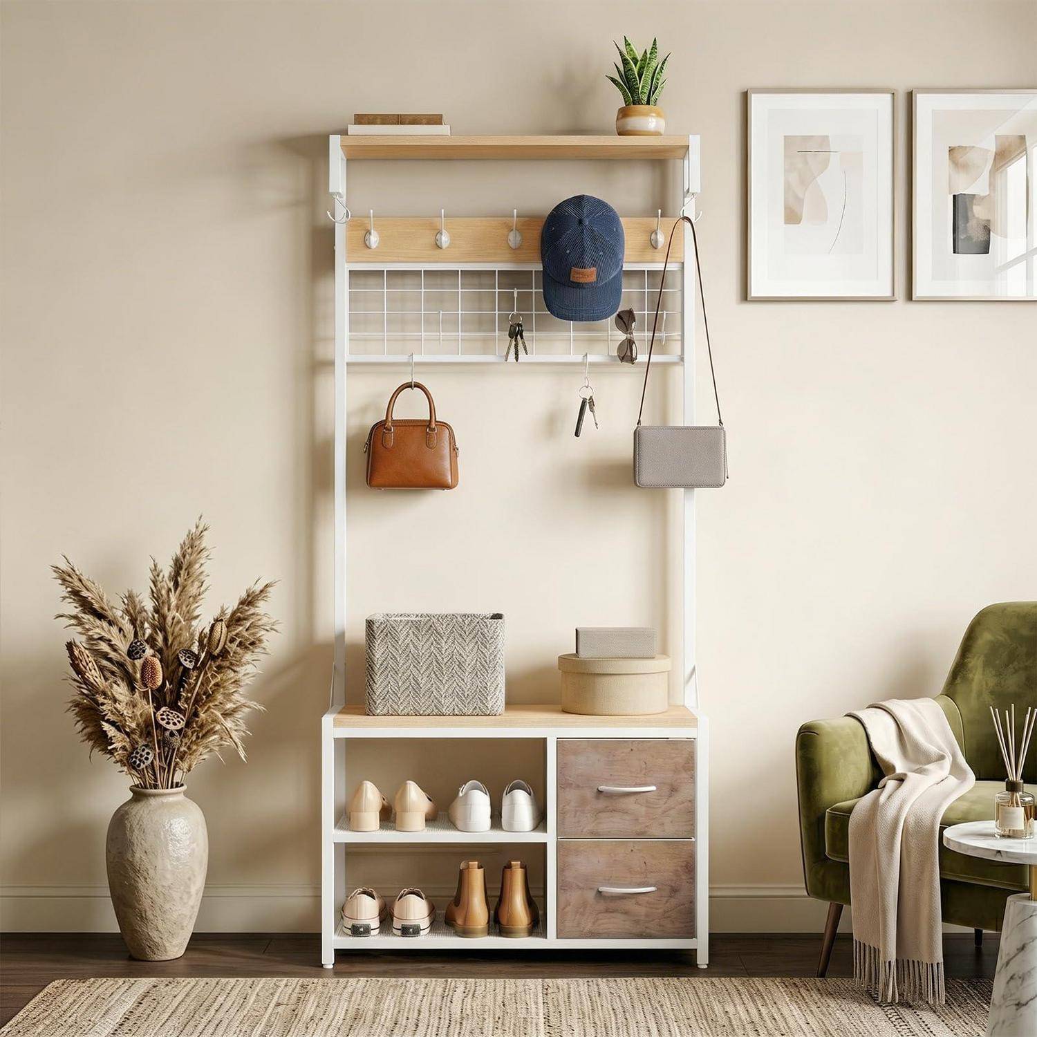 Ein kleiner Flurorganizer mit Haken, Regalen, Schubladen und Schuhaufbewahrung hält einen Hut, eine Tasche und Dekoration; ein Rahmen mit Kunstwerk und ein grüner Stuhl stehen daneben.
