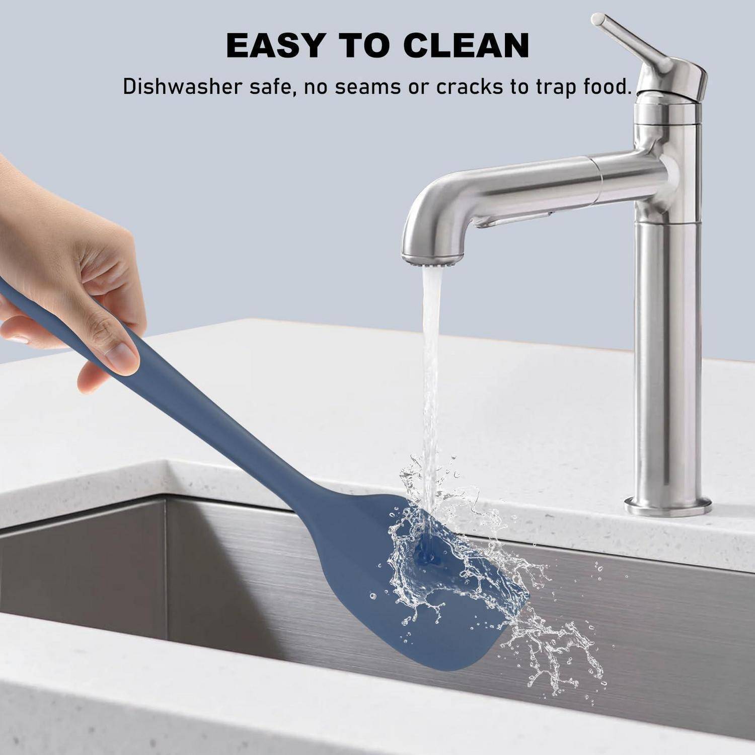 Handwäsche eines blauen Silikonlöffels unter fließendem Wasser über einem Waschbecken, mit Text, der sagt „LEICHT ZU REINIGEN