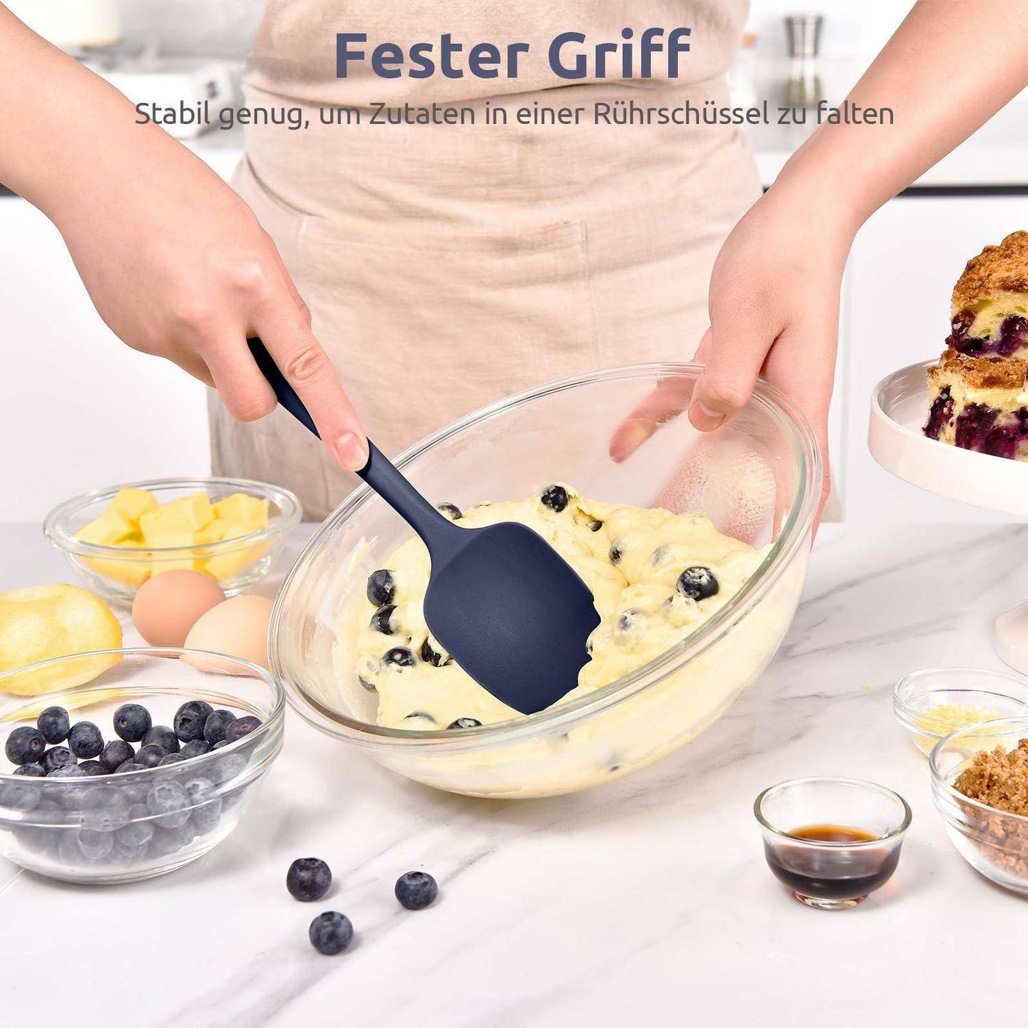 Hände, die Heidelbeeren-Teig in einer Glasschüssel mit einem Silikonspatel mischen; der Text lautet „Ester Griff