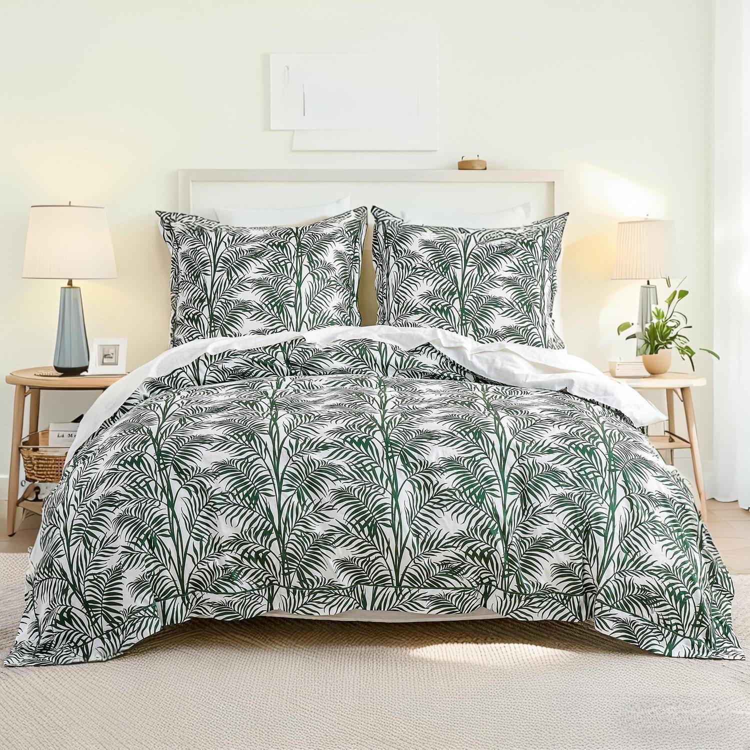 Ein ordentlich gemachtes Bett mit grüner Palmenmuster-Bettdecke und passenden Kissen, flankiert von Nachttischen und Lampen in einem hellen Schlafzimmer.