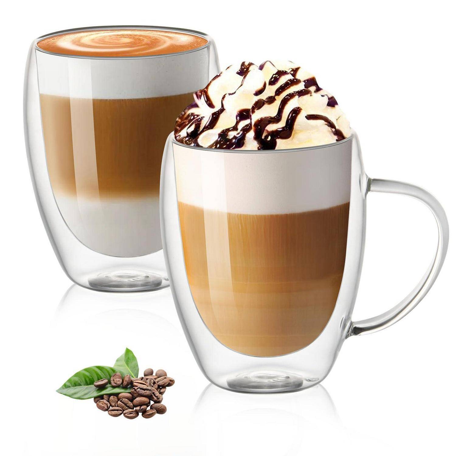 Zwei geschichtete Kaffeegetränke in durchsichtigen Glastassen, eines oben mit Schlagsahne und Schokoladensirup; Kaffeebohnen und Blätter darunter abgebildet.