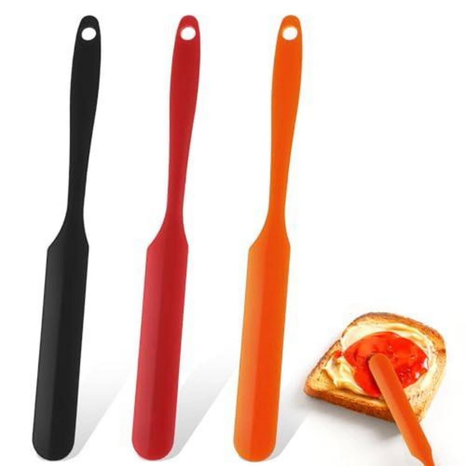 Drei langstieliger Buttermesser in Schwarz, Rot und Orange, neben einer Brotscheibe abgebildet, auf die Aufstrich aufgetragen wird.