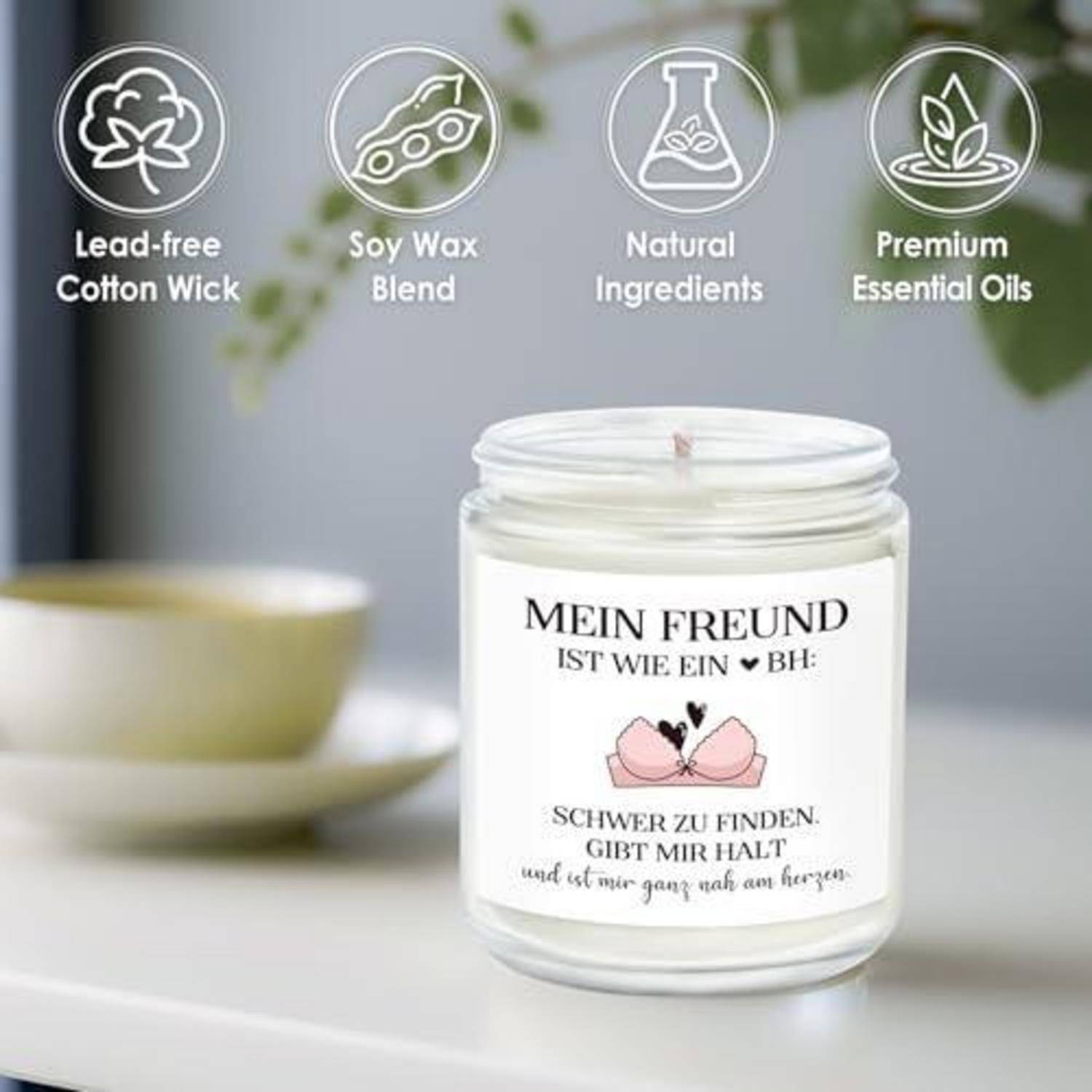 Weißes Duftkerzen-Glas mit der Aufschrift „MEIN FREUND IST WIE EIN BH" und deutschem Text, gezeigt mit Symbolen für bleifreier Baumwollwendel, Soja-Wachs-Mischung, natürliche Inhaltsstoffe und Premium-Ätherische Öle.