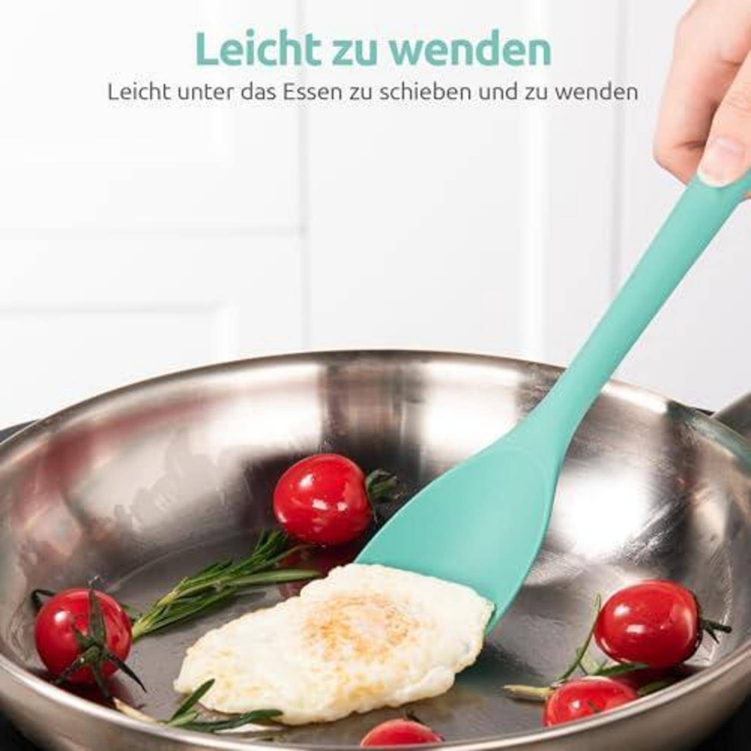Hand, die einen türkisfarbenen Spatel verwendet, um ein Spiegelei in einer Edelstahlpfanne mit Tomaten und Kräutern zu wenden; der Text lautet „Leicht zu wenden
