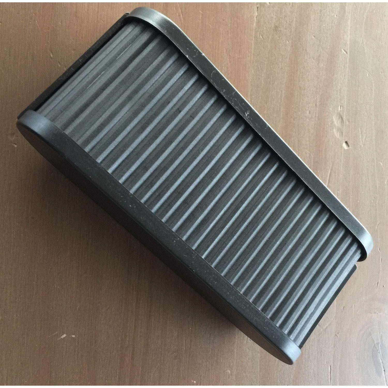 Schwarzer rechteckiger gerippter Autoluftfilter auf einer Holzoberfläche, diagonal angeordnet.