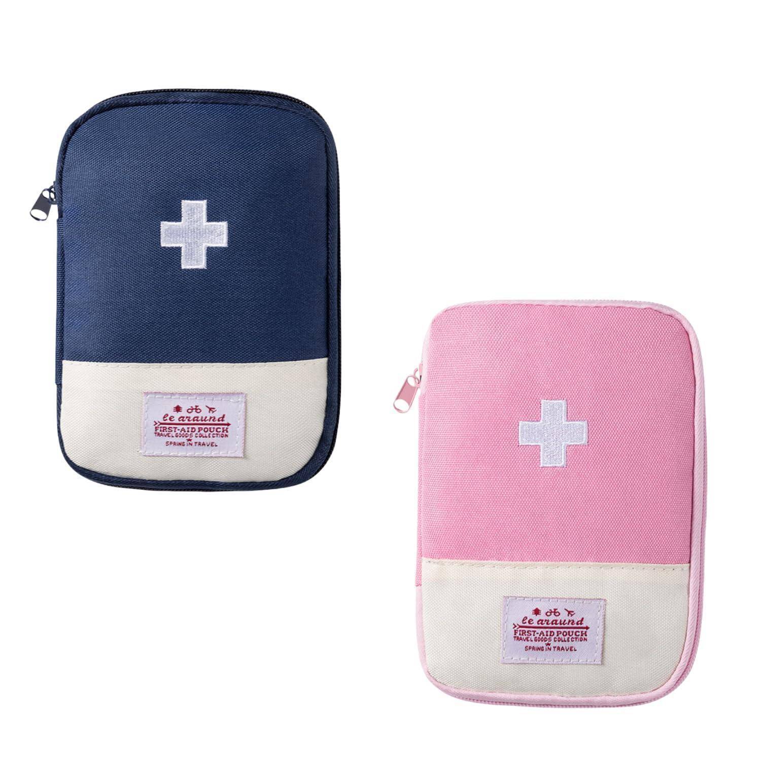 Zwei Reisekulturtaschen mit Reißverschluss werden nebeneinander gezeigt, eine in Marine und eine in Rosa, jeweils mit weißem Kreuz und vorderem Etikett.