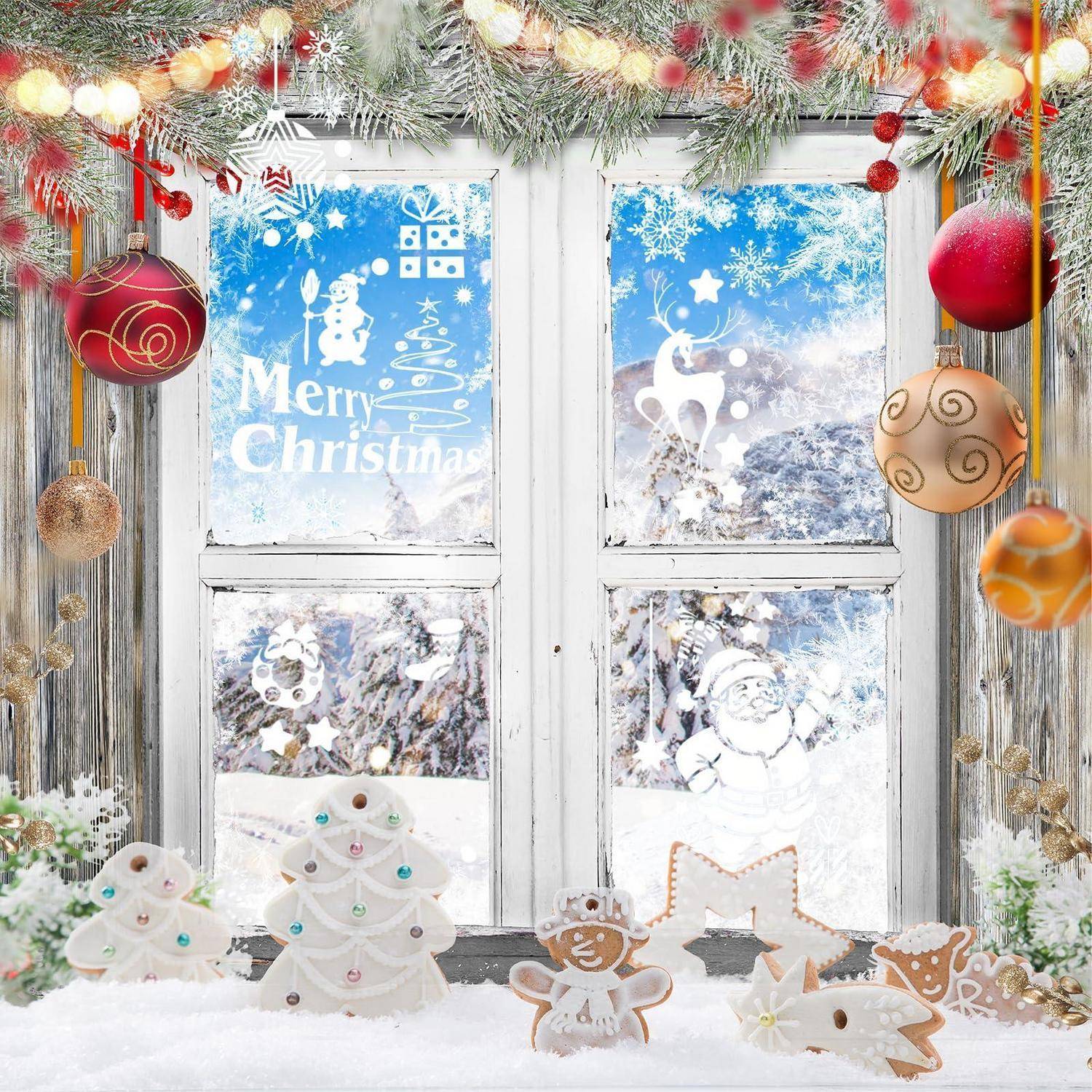 Festliche Weihnachtsschaufensterauslage mit schneebedeckten Scheiben, „Frohe Weihnachten"-Text, Weihnachtskugeln, Girlanden und Lebkuchen auf Schnee.