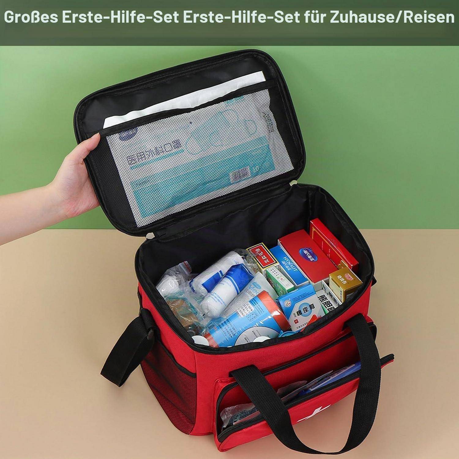 Offene rote Erste-Hilfe-Tasche mit Vorräten und Boxen innen, gezeigt mit einer Hand, die den Deckel offen hält; Text besagt „Großes Erste-Hilfe-Set Erste-Hilfe-Set für Zuhause/Reisen".