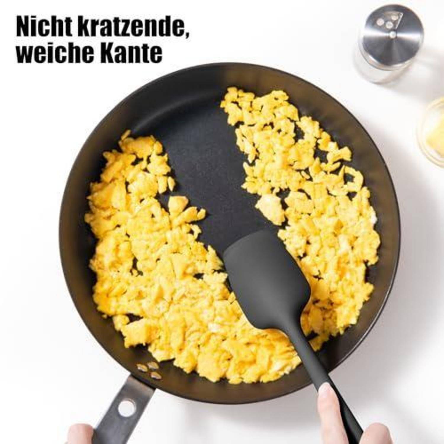 Draufsicht auf eine Antihaft-Bratpfanne mit Rühreiern und einem Spatel; der Text lautet „Nicht kratzende, weiche Kante