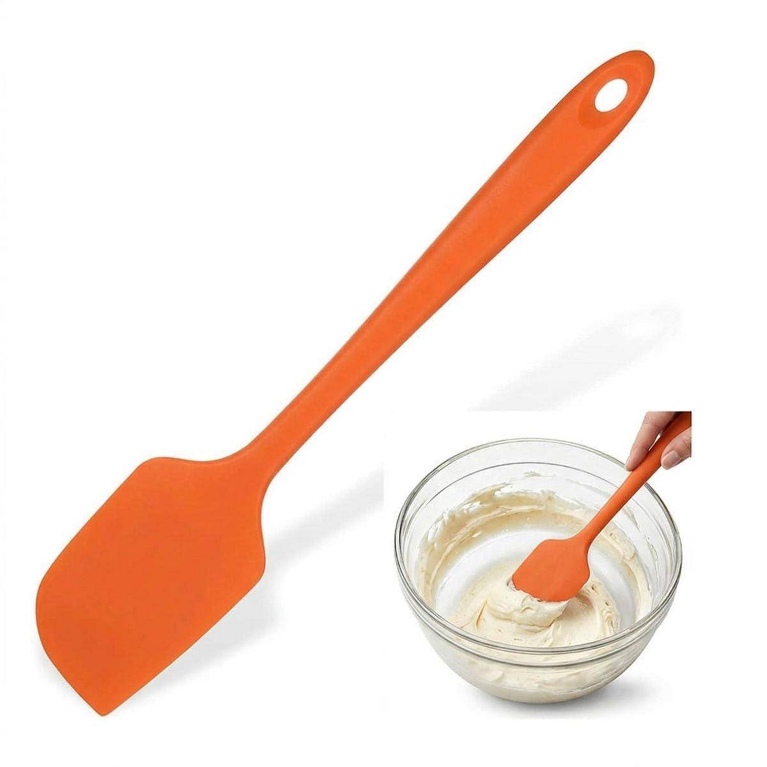 Orangel Silikonspatel mit einer Hand, die Teig in einer Glasschissel rührt, wobei das Produkt als Backwerkzeug gezeigt wird.