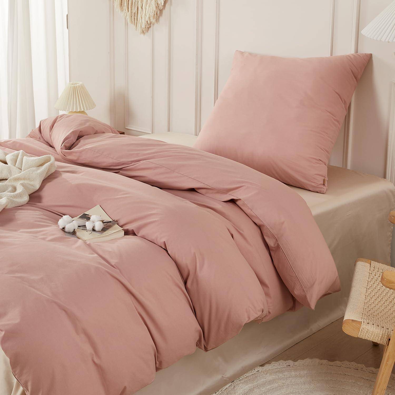 Rosafarbenes Bettwäsche-Set auf einem ordentlich gemachten Bett, mit passendem Kissen und Bettdecke in einer gemütlichen Schlafzimmerumgebung.