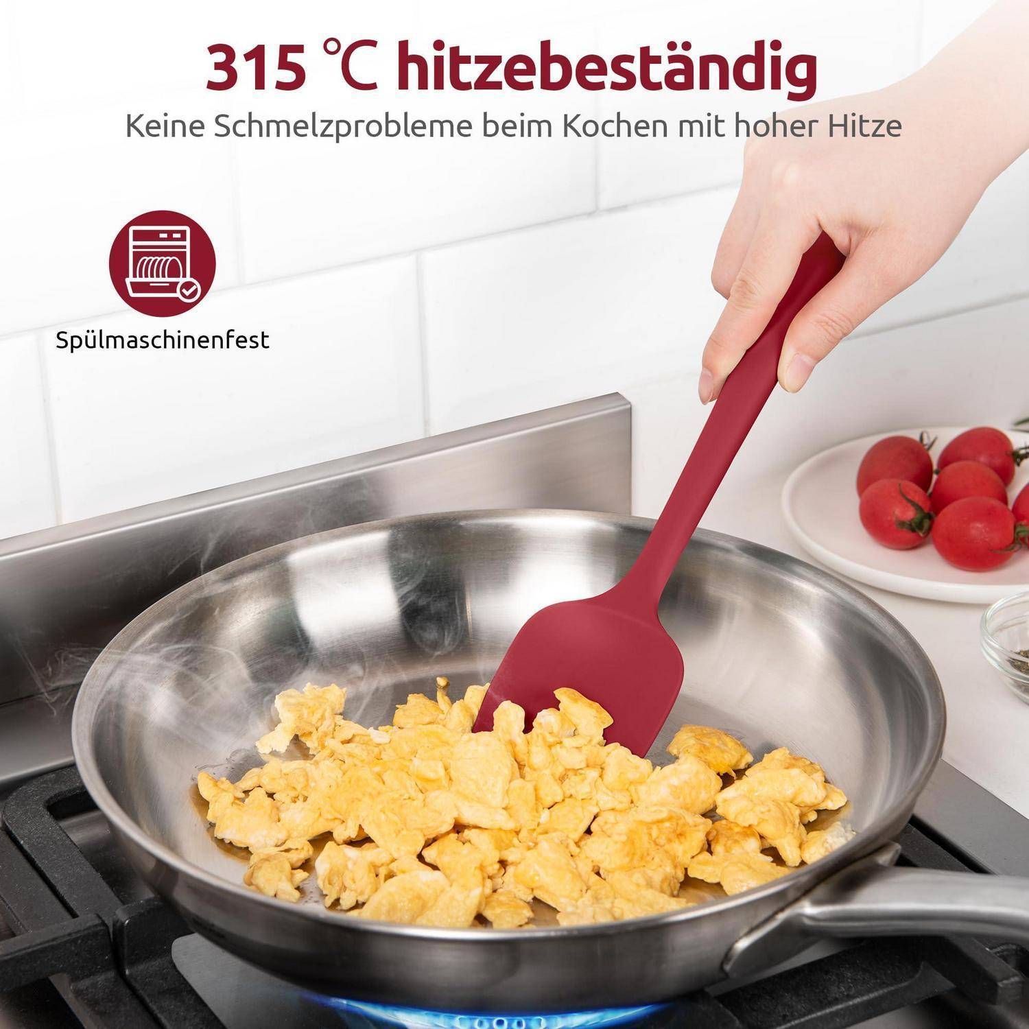 Hand hält einen roten Spatel und rührt Rührei in einer Edelstahlpfanne um; der Werbetexte sagt „315 °C hitzebeständig