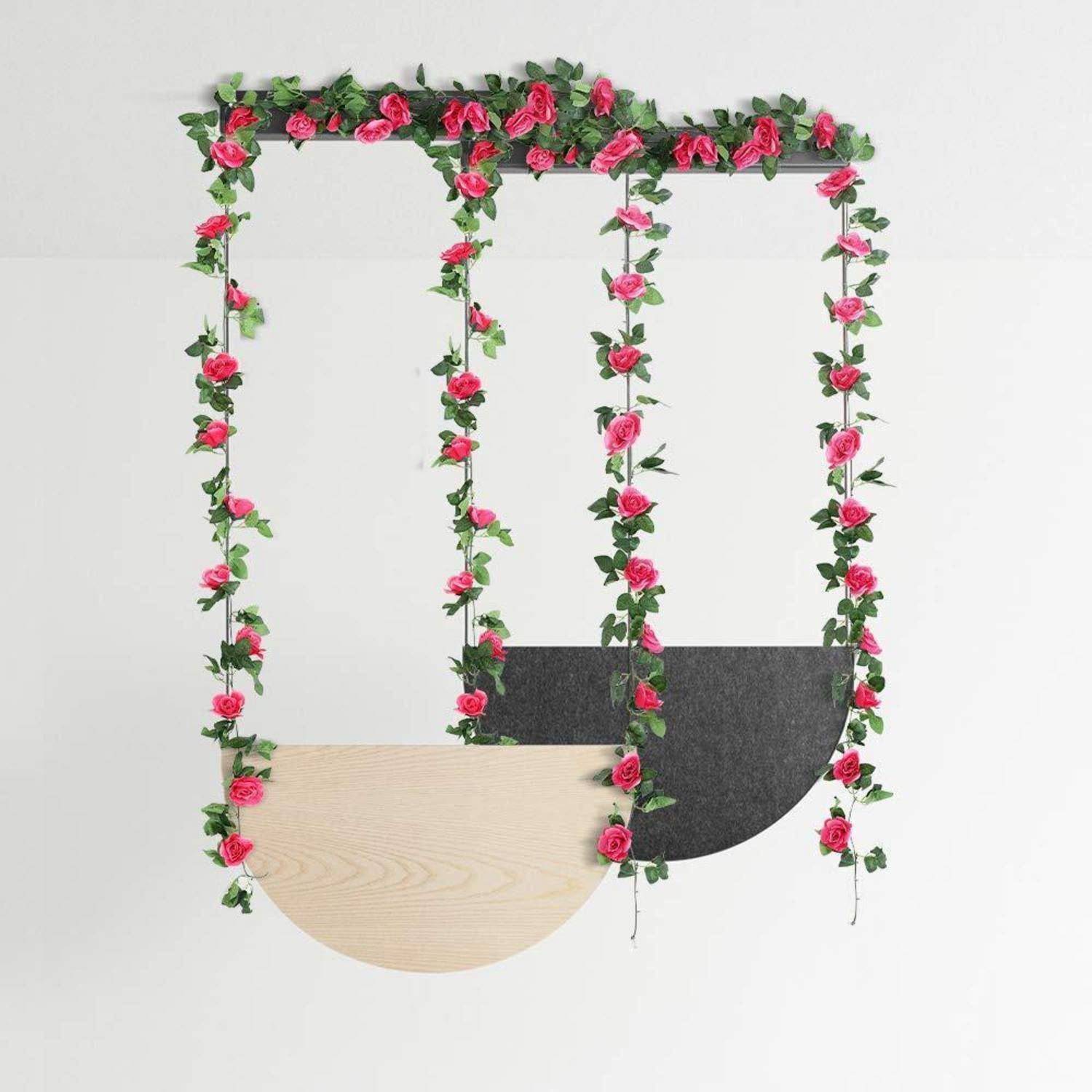 Dekorativer Blumenrahmen mit hängenden rosa Rosengirlanden und zwei halbkreisförmigen Paneelen, eines aus hellem Holz und eines in dunkelgrau, auf weißem Hintergrund.