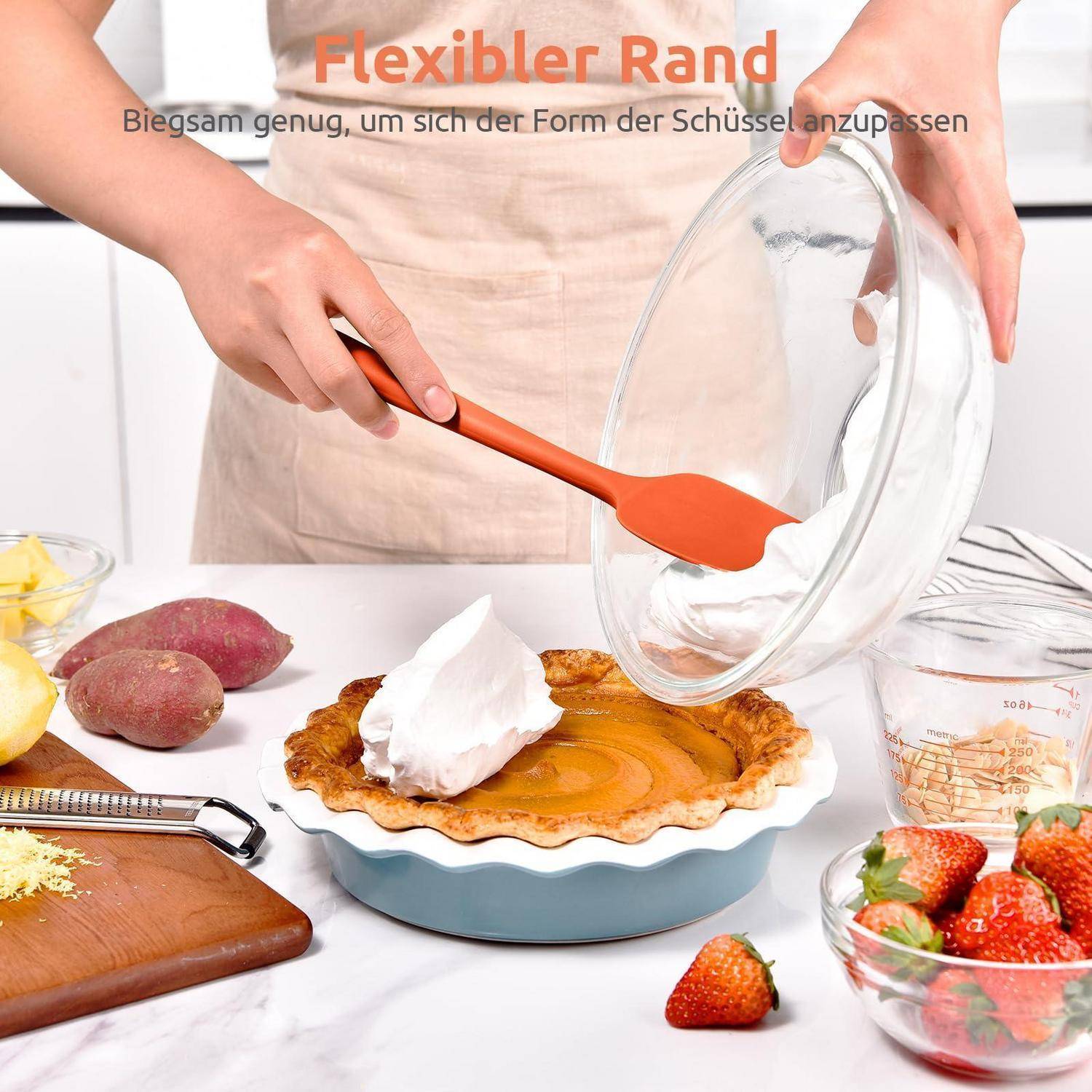 Eine Person verwendet einen flexiblen orangefarbenen Spatel, um einen Kuchen aus einer Glaspieform auf einen blauen Teller zu übertragen; deutscher Text sagt „Flexibler Rand
