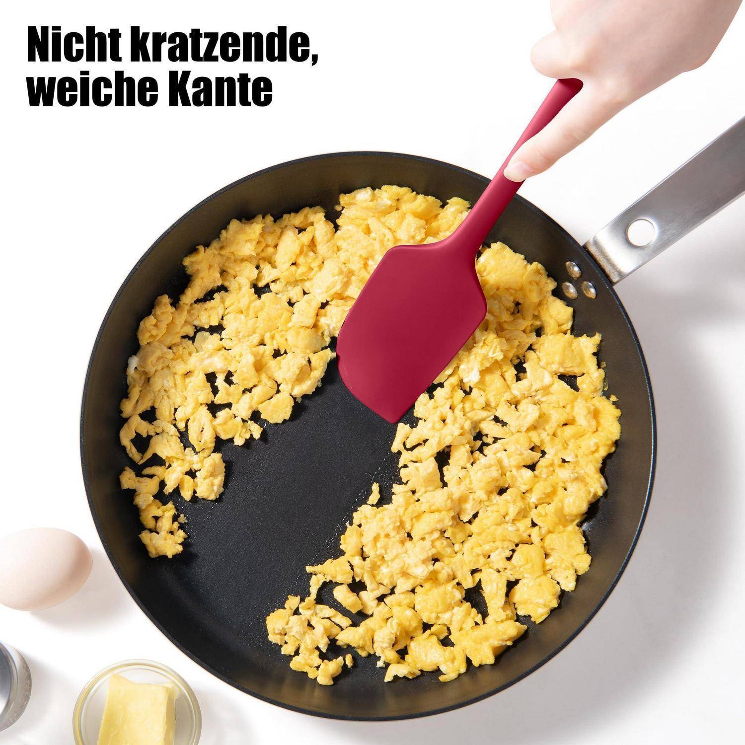 Manuelles Rühren von Rühreiern in einer Bratpfanne mit einem Silikonspatel; deutscher Text lautet „Nicht kratzende, weiche Kante