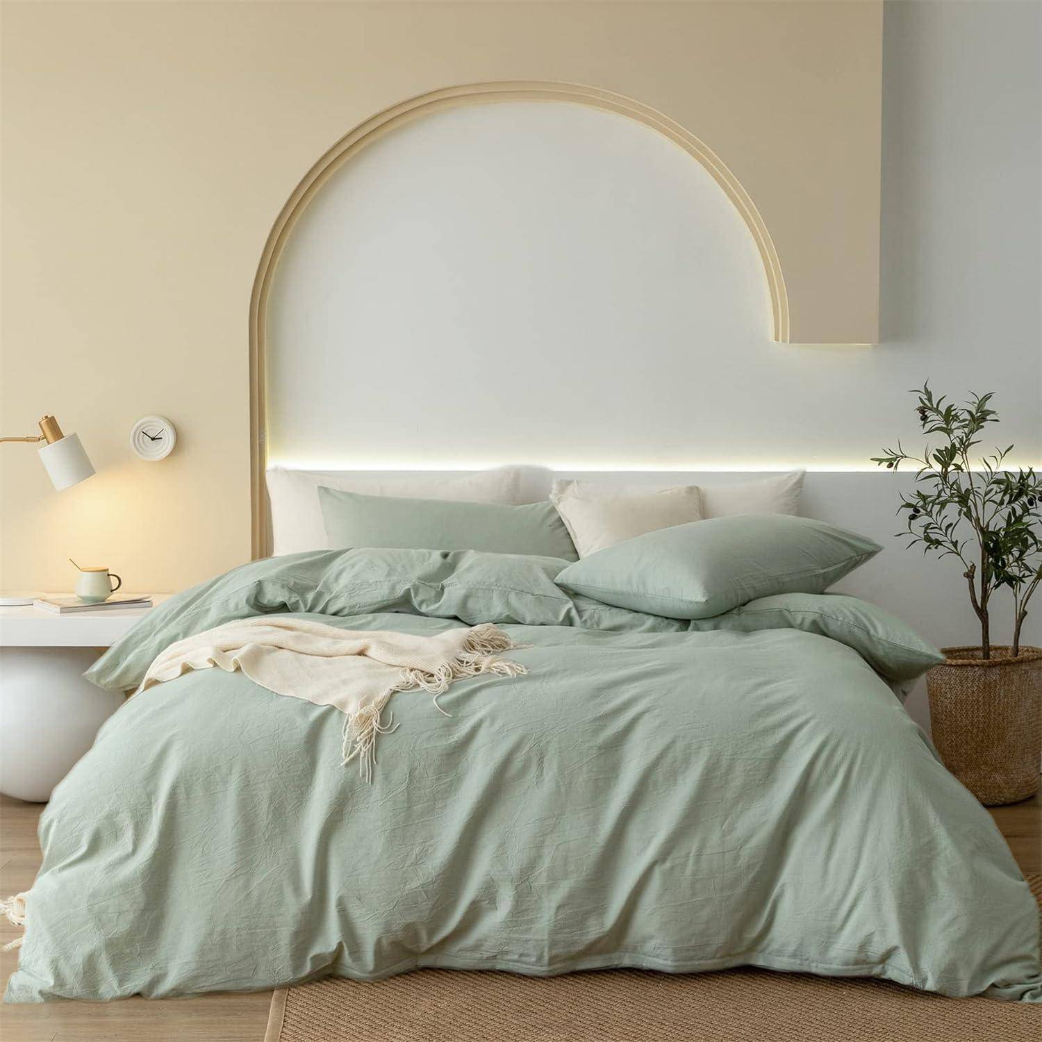 Ein ordentlich gemachtes Bett mit hellgrüner Bettwäsche und Kissen in einem minimalistischen Schlafzimmer, mit einer Nachttischlampe, einer Wanduhr und einer Topfpflanze.
