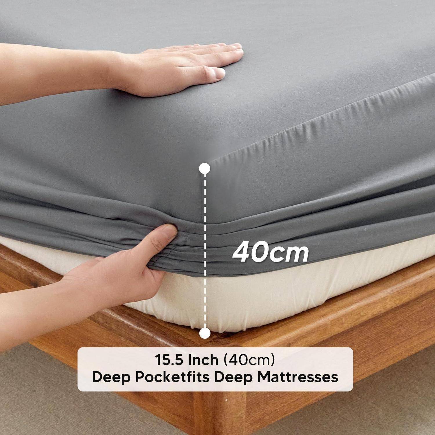 Hände zeigen einen Matratzenbezug, der auf eine 40 cm tiefe Matratze passt, beschriftet mit „15,5 Zoll (40 cm) Tiefe Taschenpassen für tiefe Matratzen".