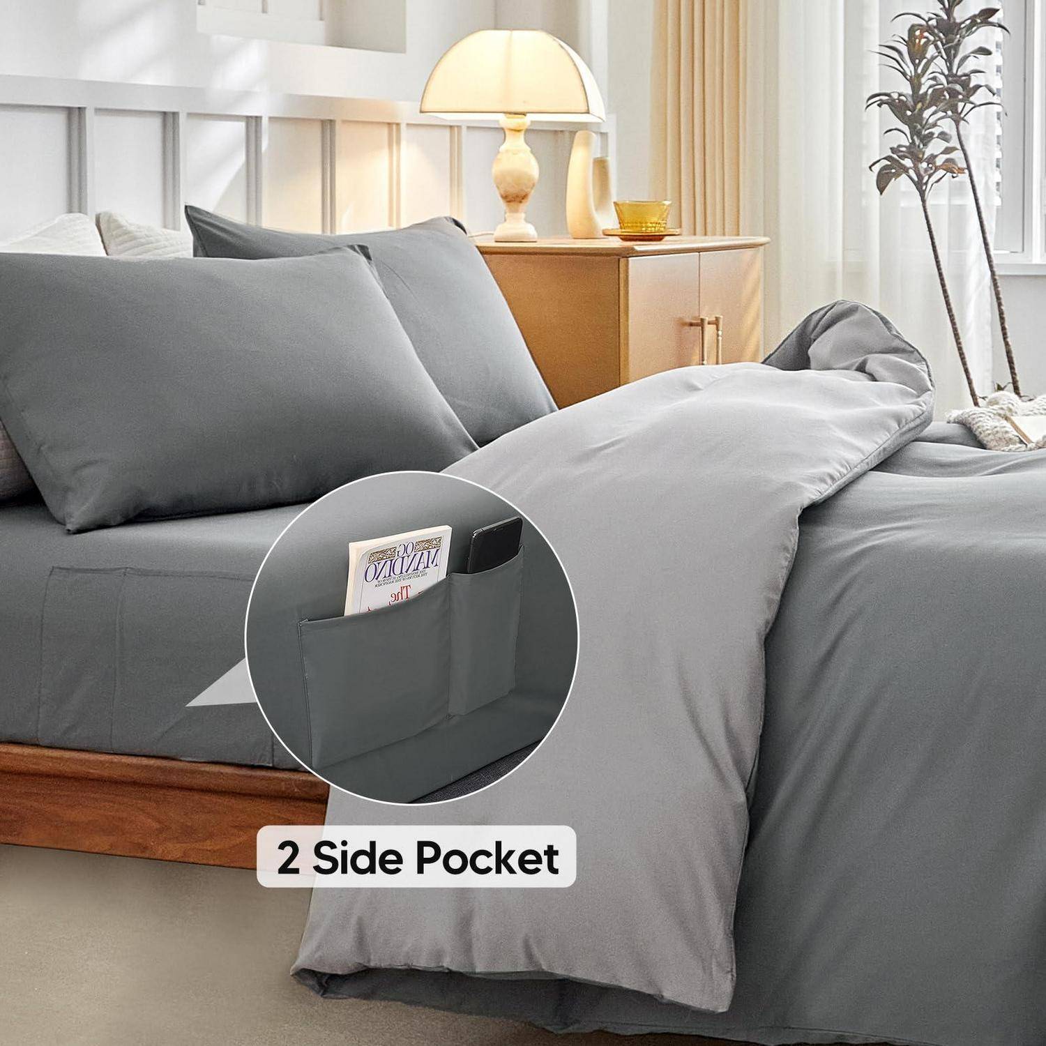 Graue Bettdecke mit Seitentasche zum Verstauen von Gegenständen, dargestellt auf einem ordentlich gemachten Bett in einem hellen Schlafzimmer; das Etikett liest „2 Side Pocket".